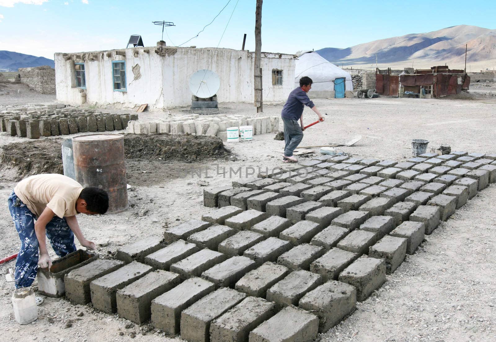 MONGOLIA, AUGUST 06, 2008 -  two  mongolian boys prepare  a brick for construction of house