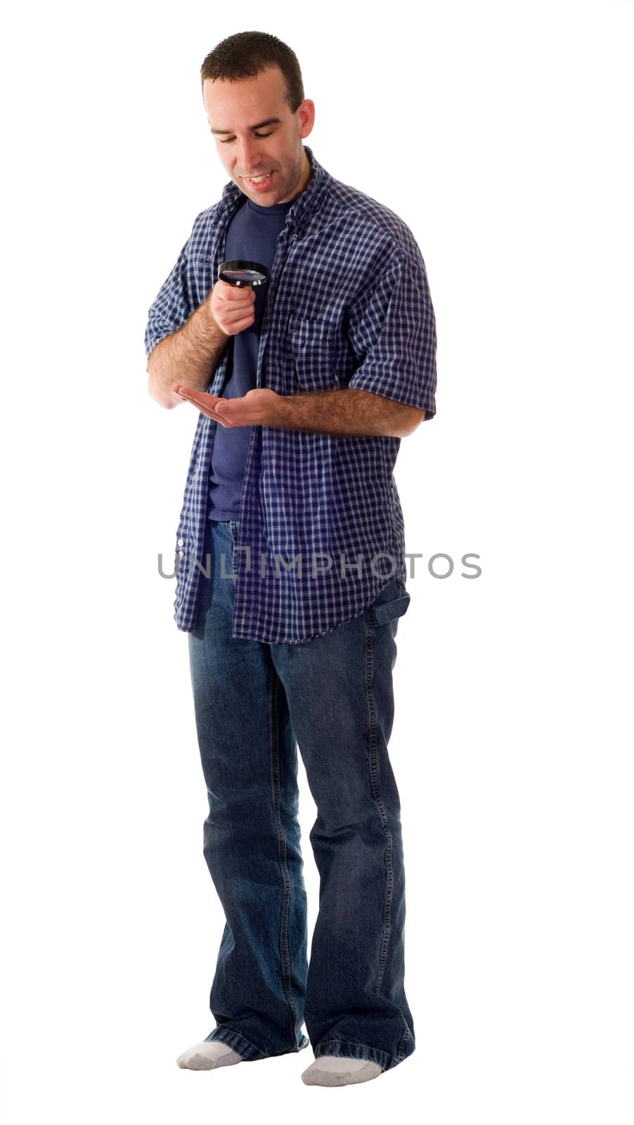 A full body view of a man examining his hand with a magnifying glass, isolated against a white background