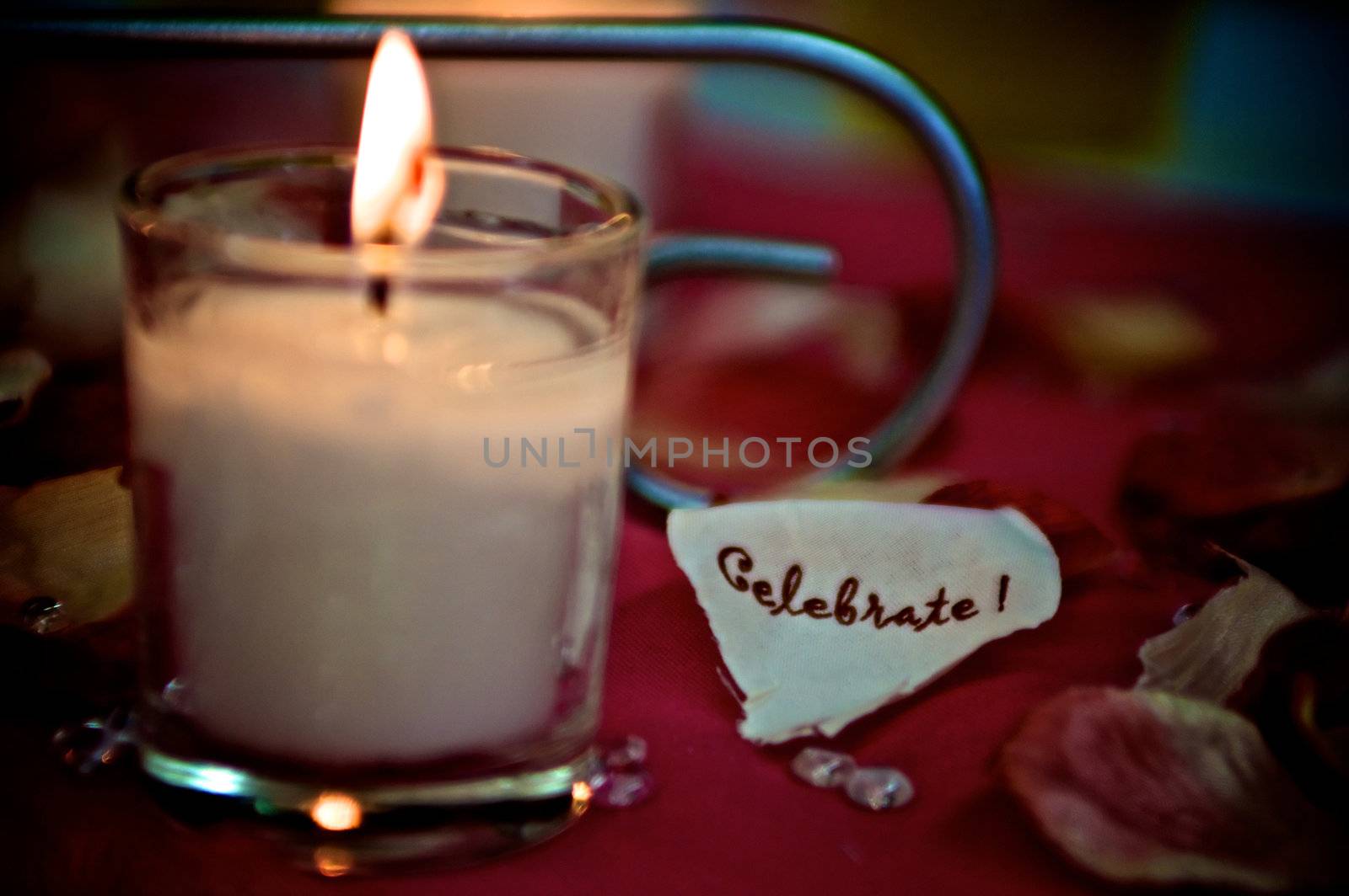 Celebrate written on a paper heart next to a small lit candle