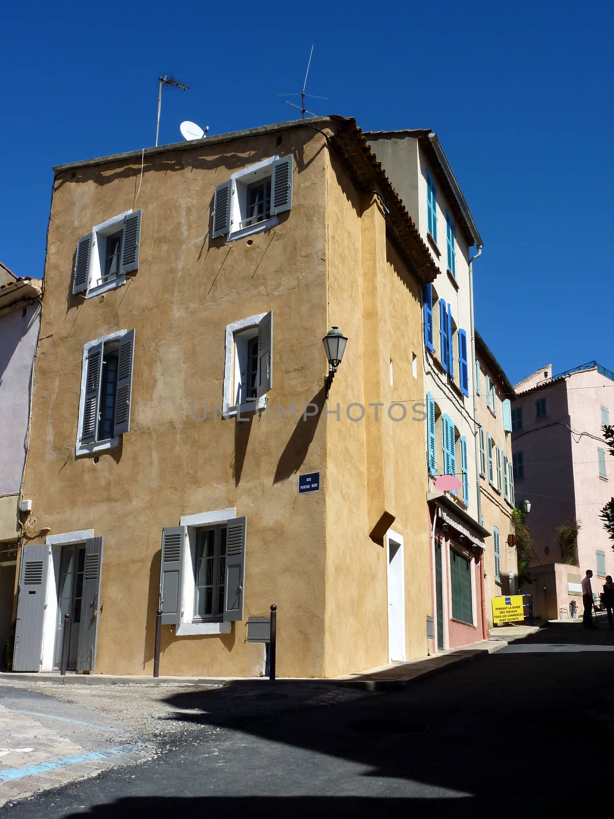 Colored house with shutters in a street of Saint-Tropez, south of France, by beautiful weather