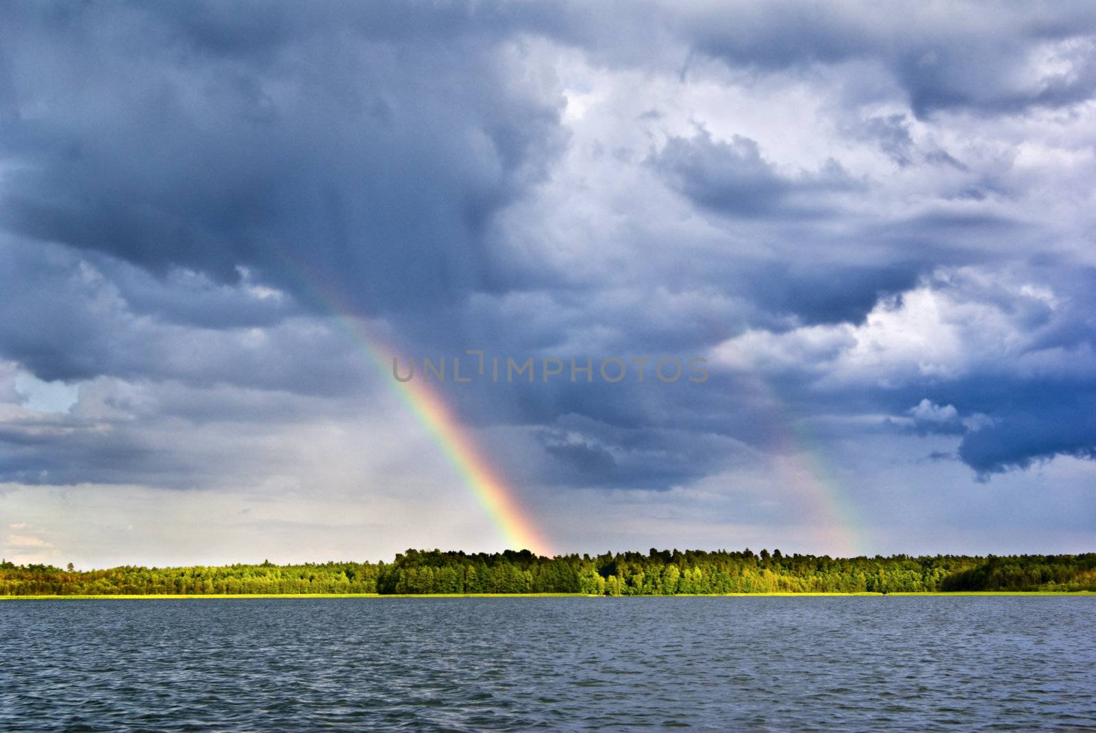 Double rainbow in the moody sky over lake. aRGB.