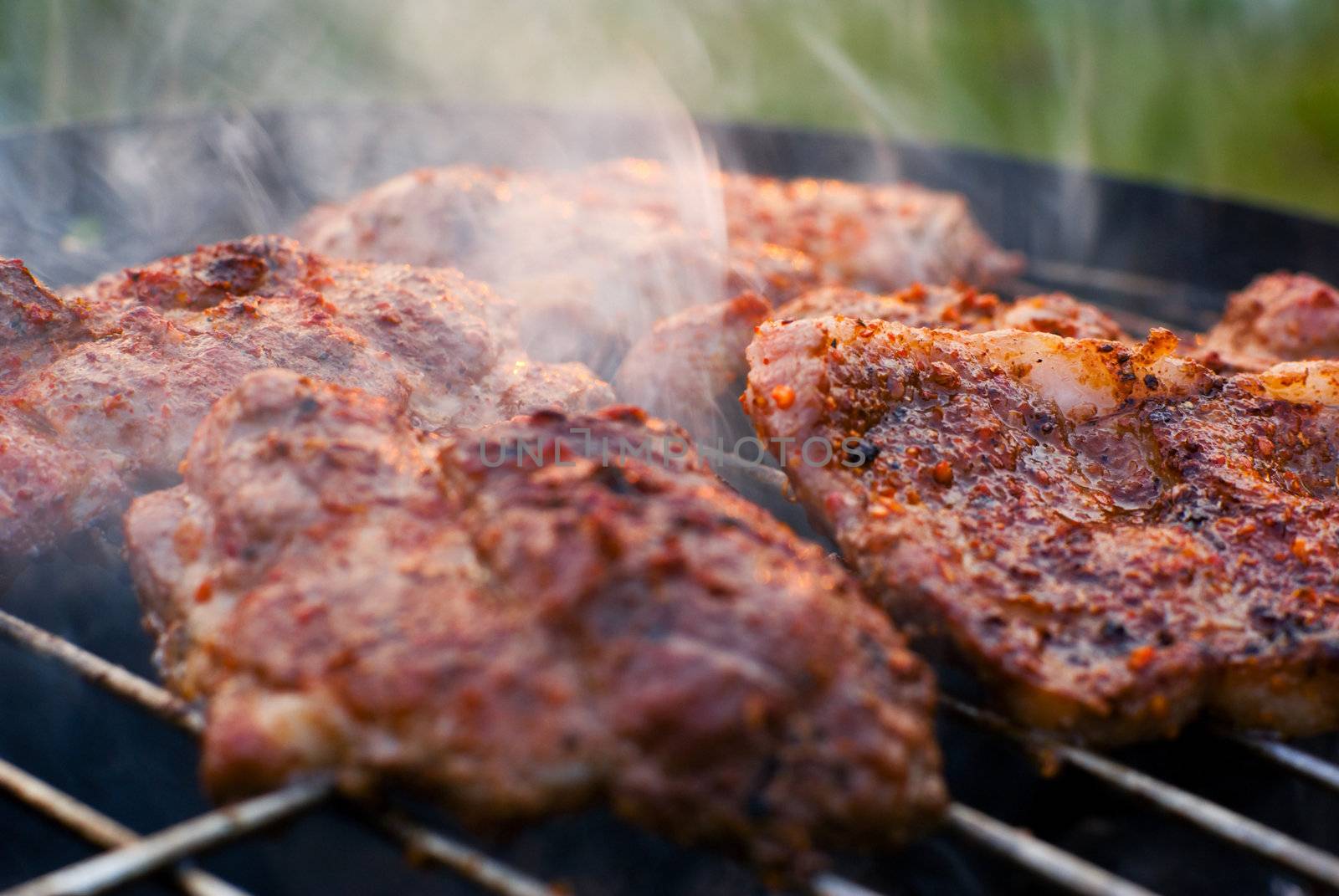 Delicious chuck steaks on the grill. Shallow depth of field.