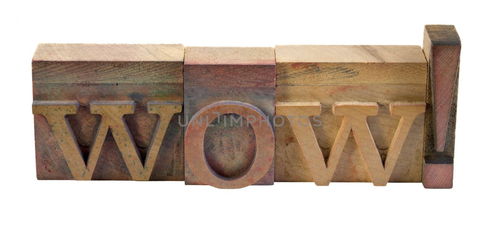 the exclamation word Wow in vintage wooden letterpress type blocks, stained by color inks, isolated on white