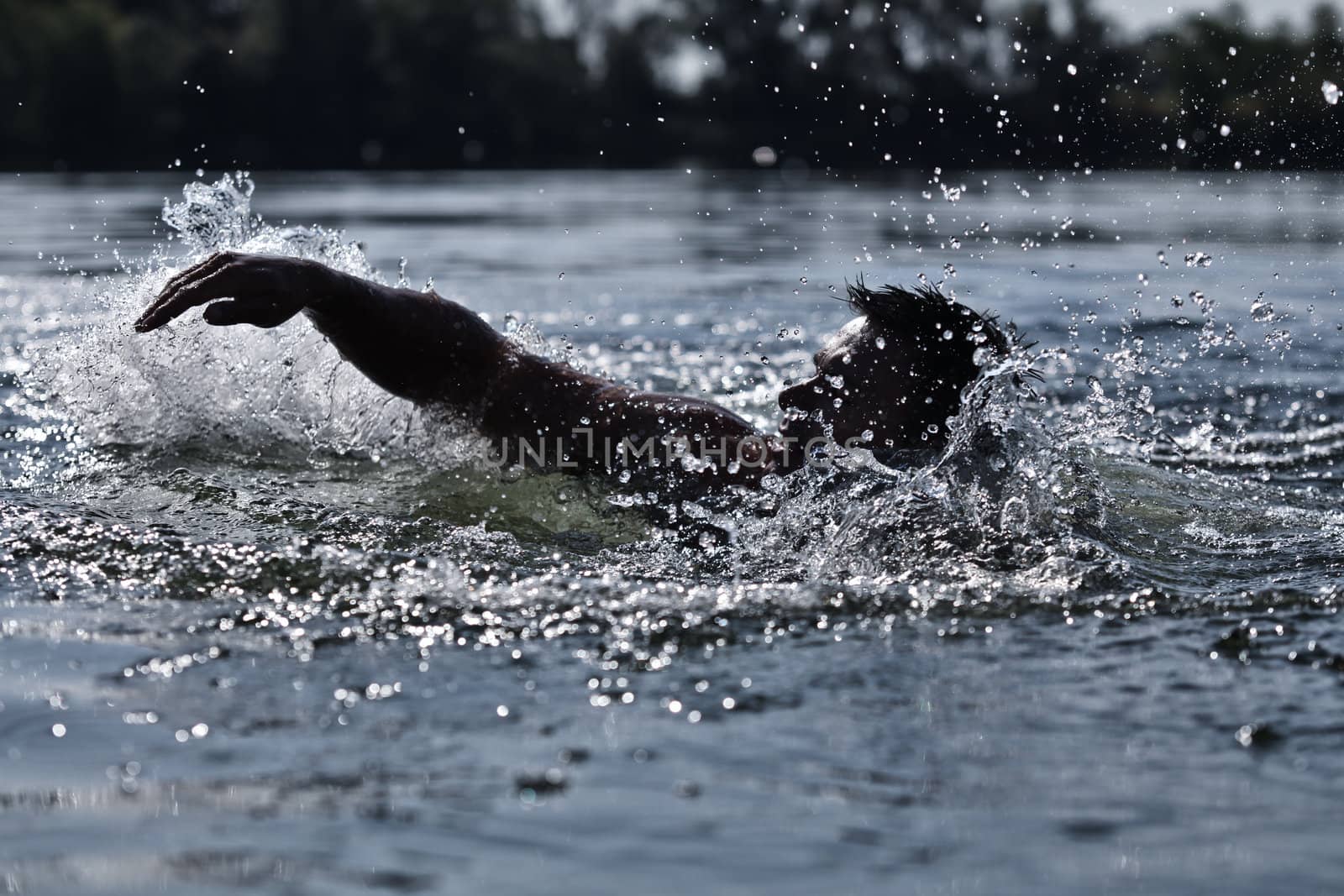 Photo Of A Man Swimming And Creating Splashes Of Water Drops