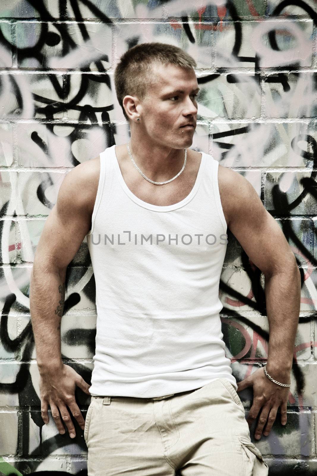 Portrait Of A Sexy Young Man In Undershirt On A Graffiti Wall Background