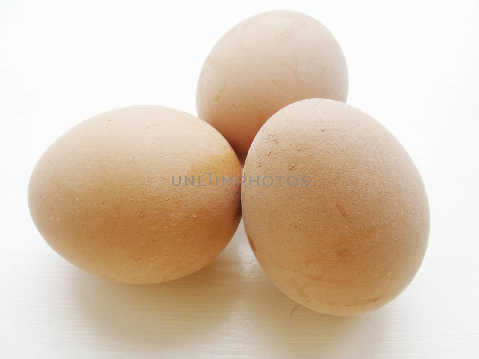 Three chicken brown eggs on a table close up
