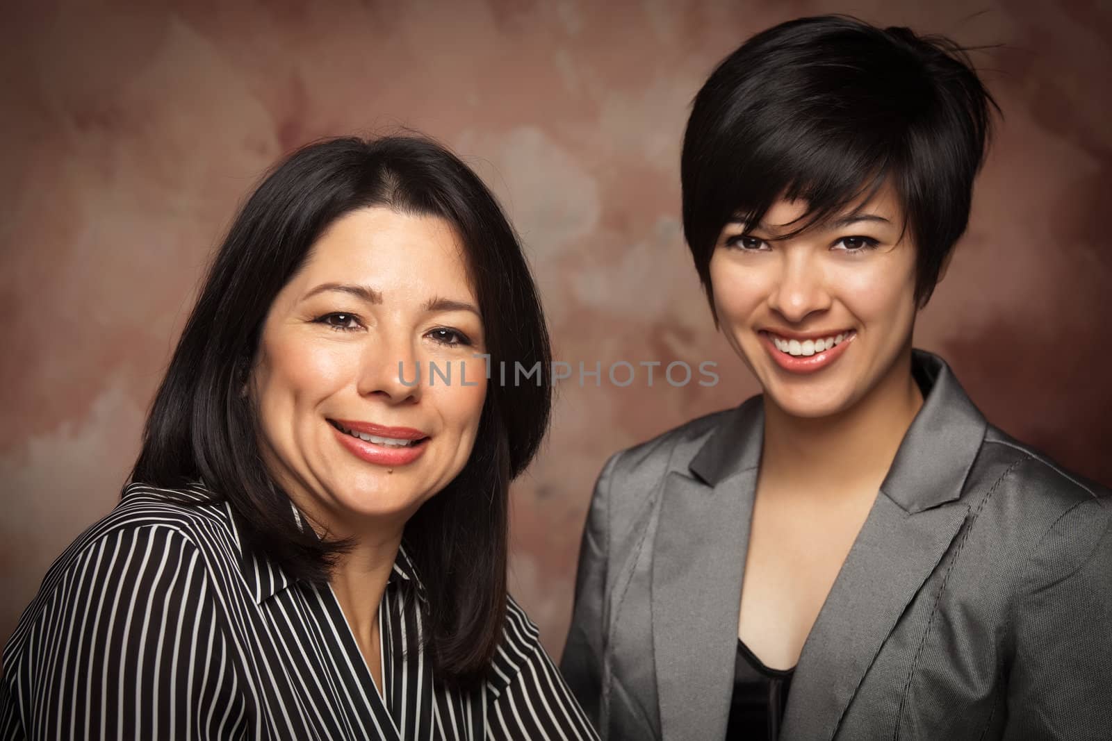 Attractive Multiethnic Mother and Daughter Studio Portrait on a Muslin Background.