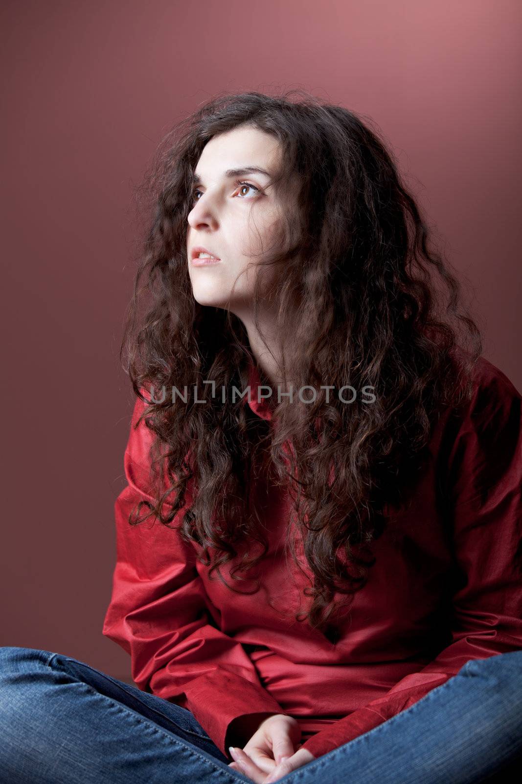 girl sitting on the ground on a red background