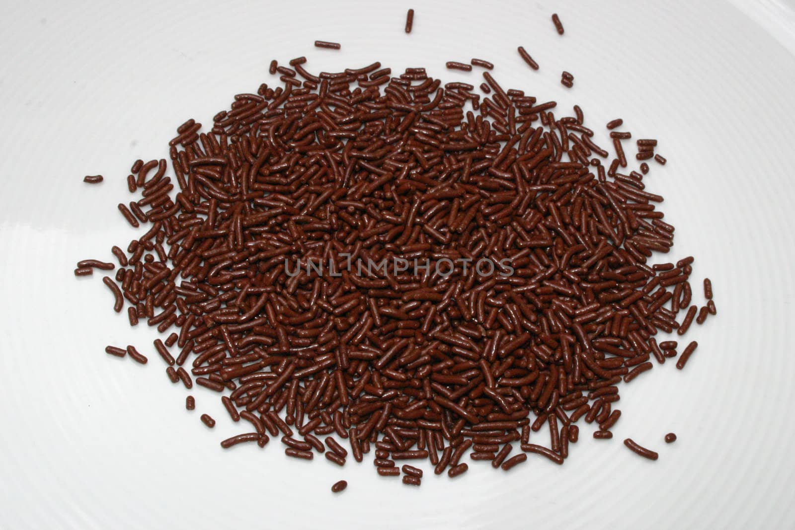 Pile of chocolate crumbles on white background for baking