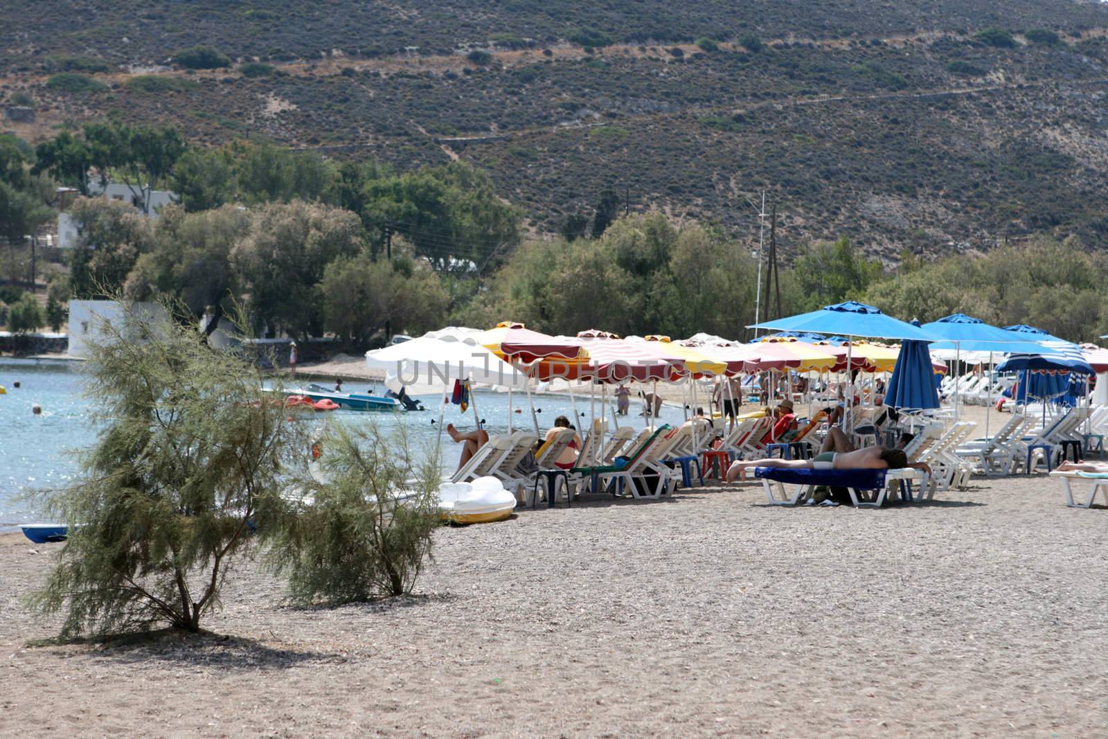 umbrellas and sunbeds on  beach patmos island greece