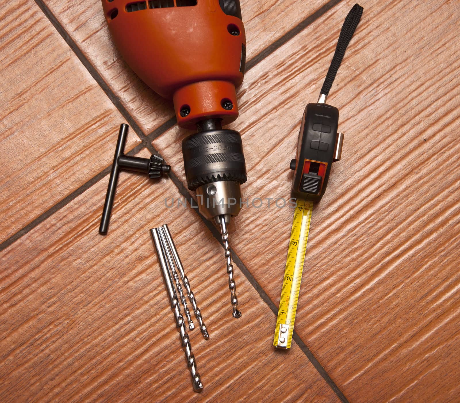 drill with roulette lying on tiled to floor