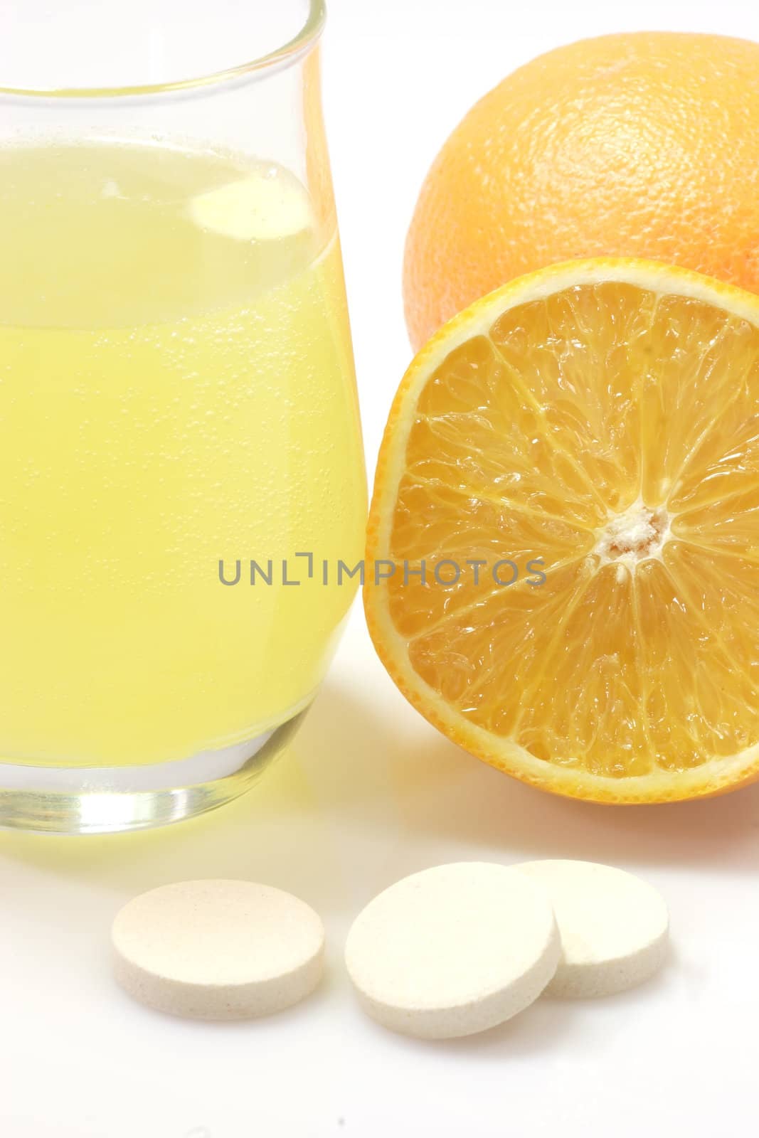 Glas of fizzy liquid with Effervescent tablets on bright background