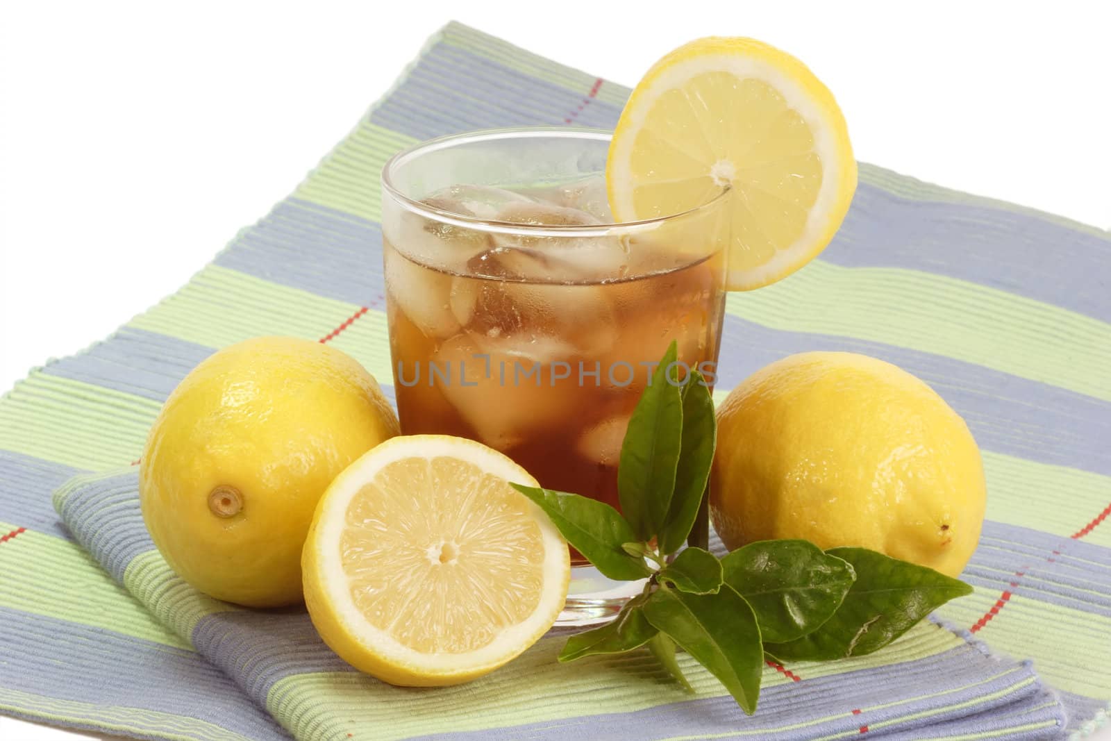 A glass full of Ice Tea with a lemon slice on bright background