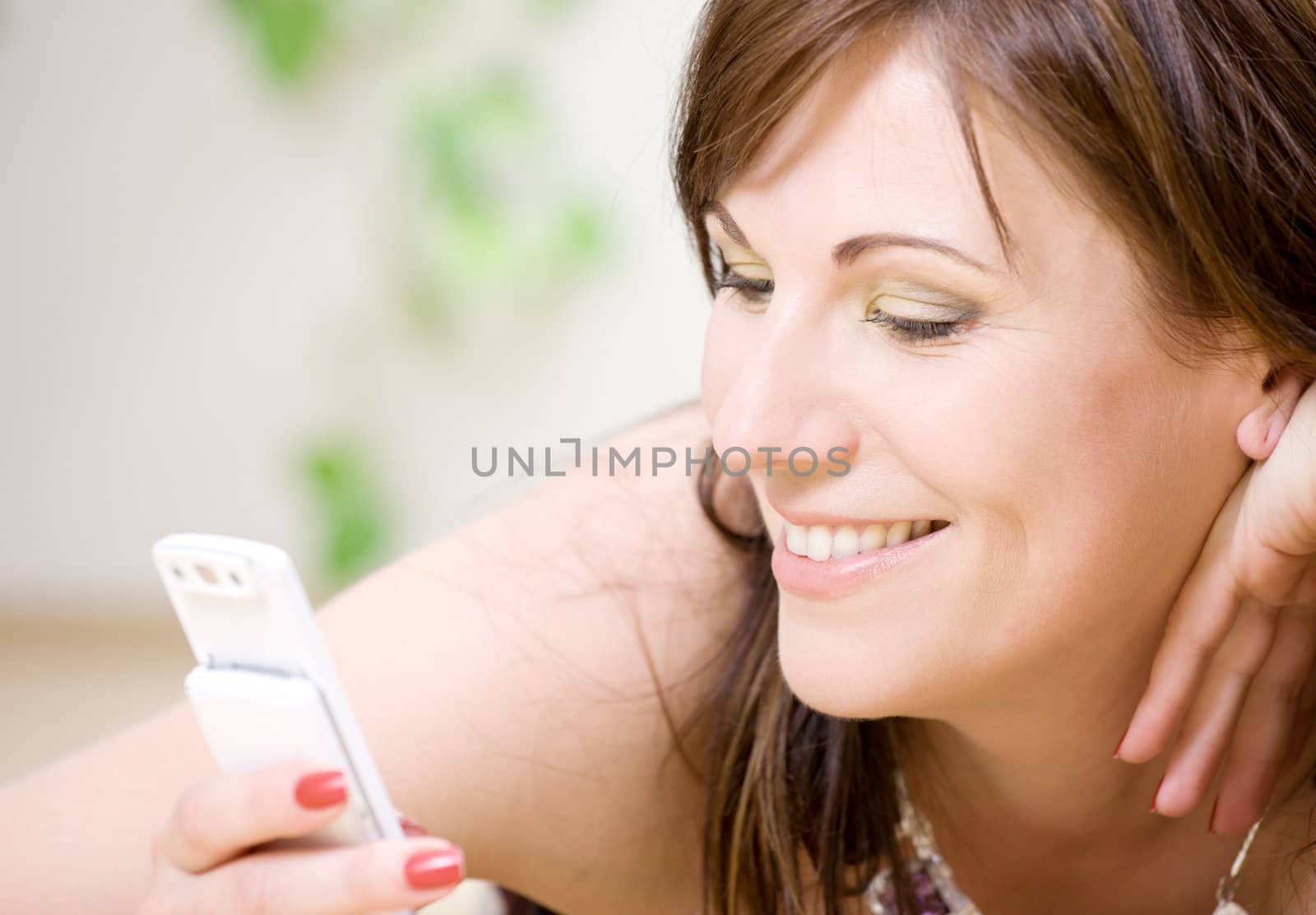 portrait of happy woman with white phone (focus on smile)