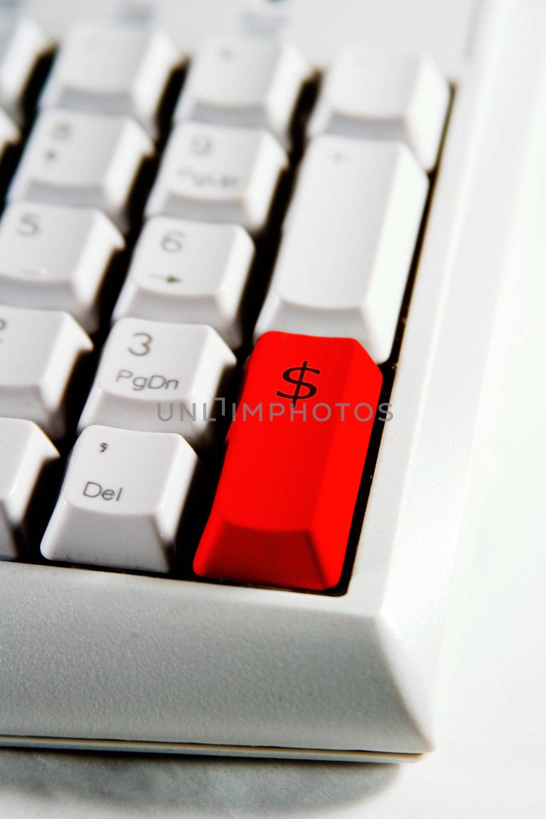 Desktop computer keyboard number pad with dollar sign on a red enter key.