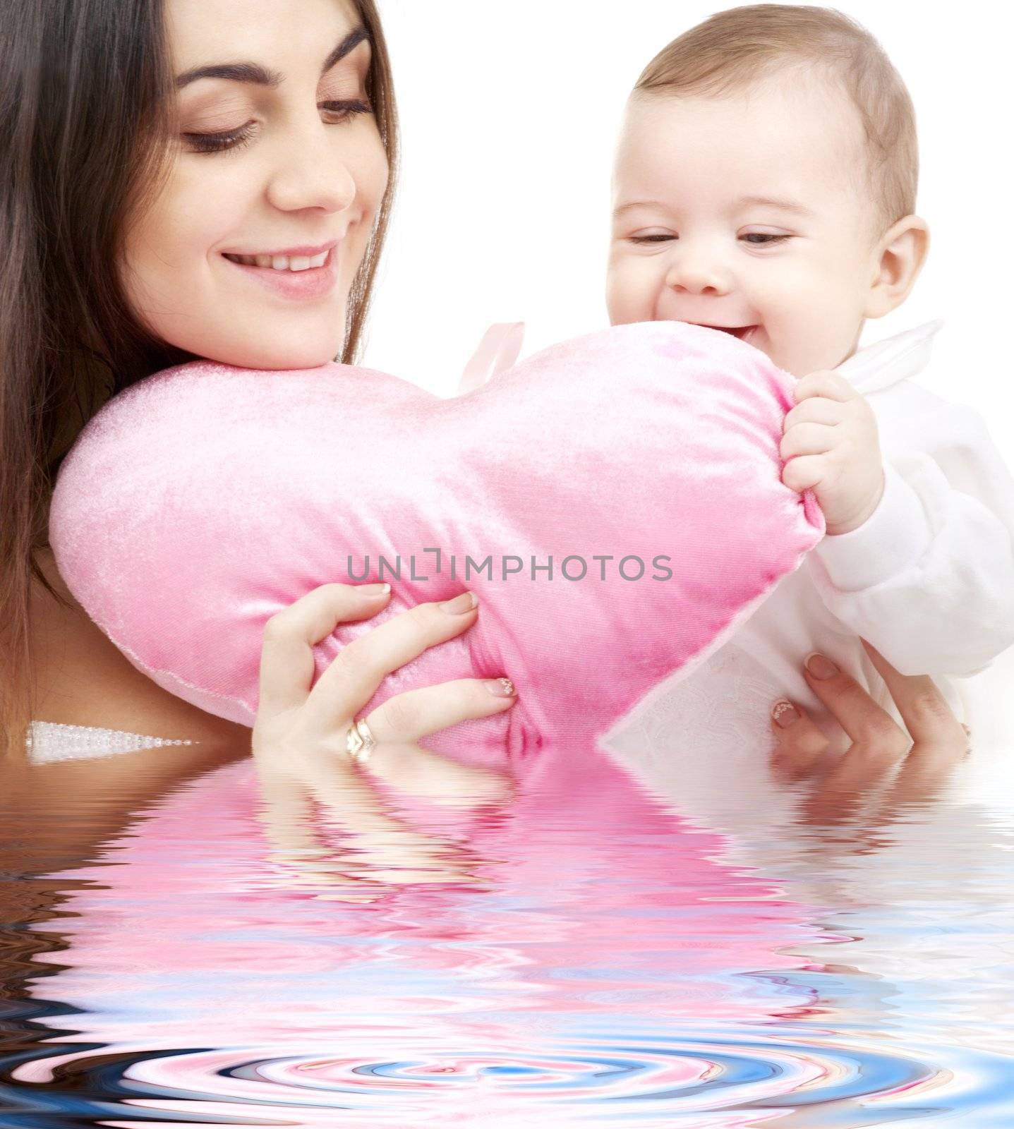 happy baby and mama with heart-shaped pillow in water