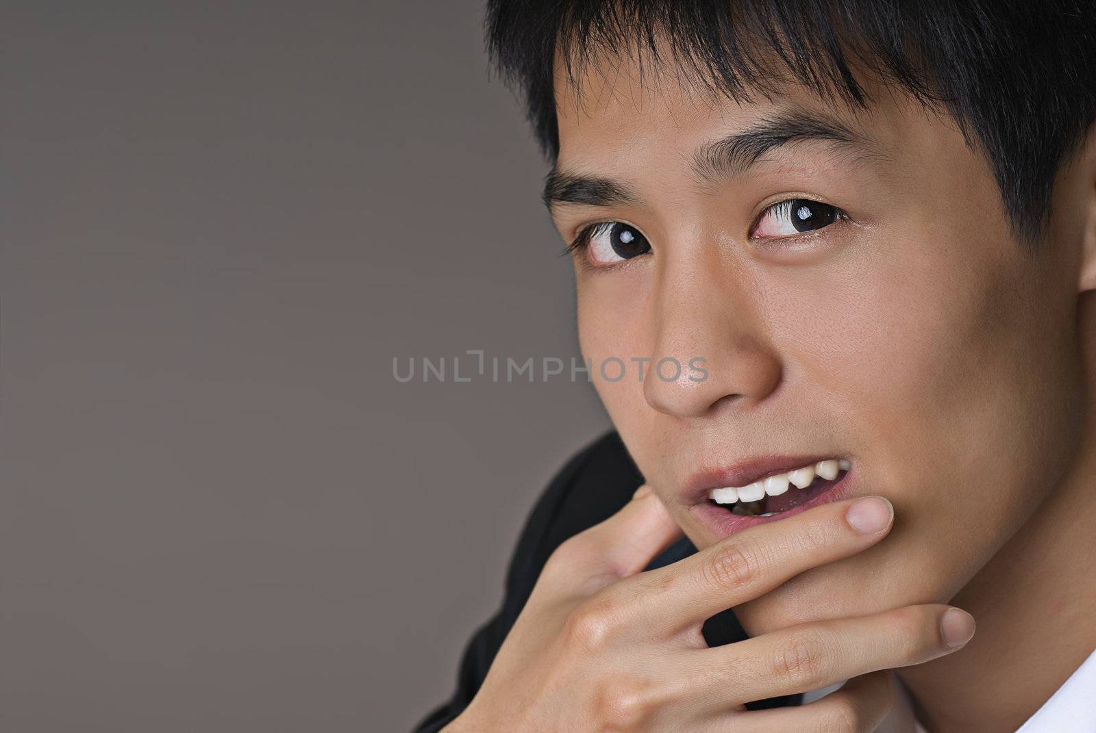 Smart young business man of Asian on gray background.