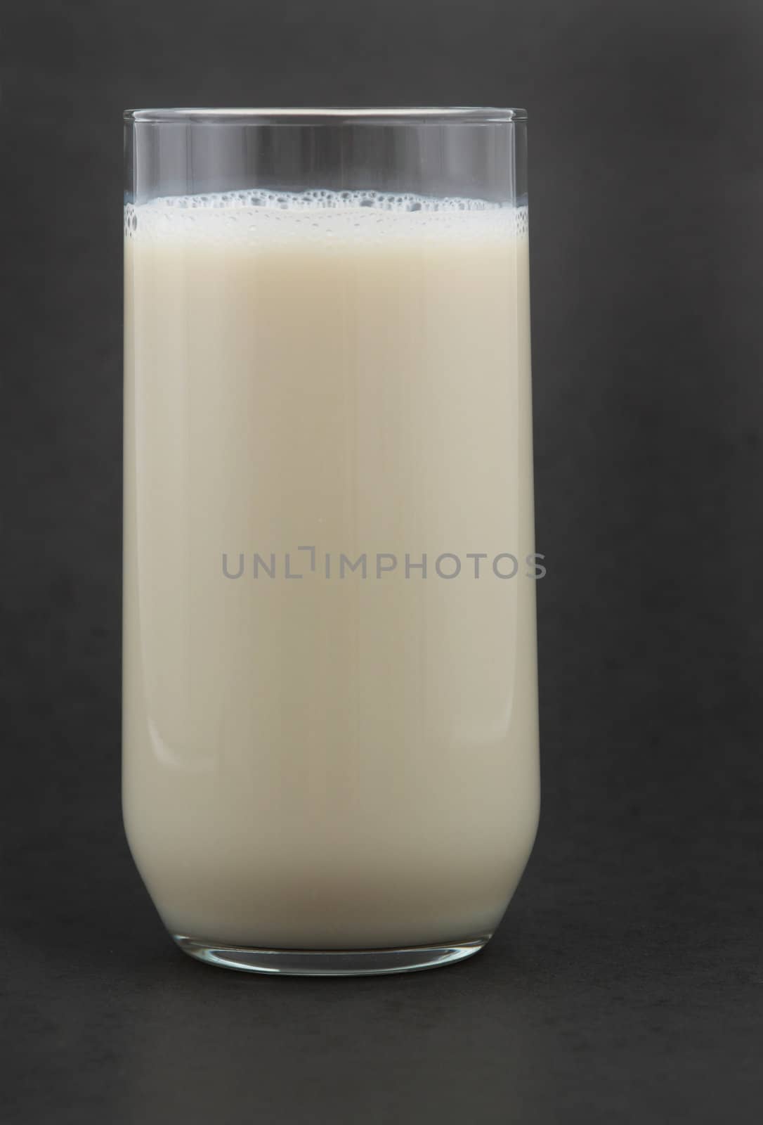 big glass of natural soy beverage, white background