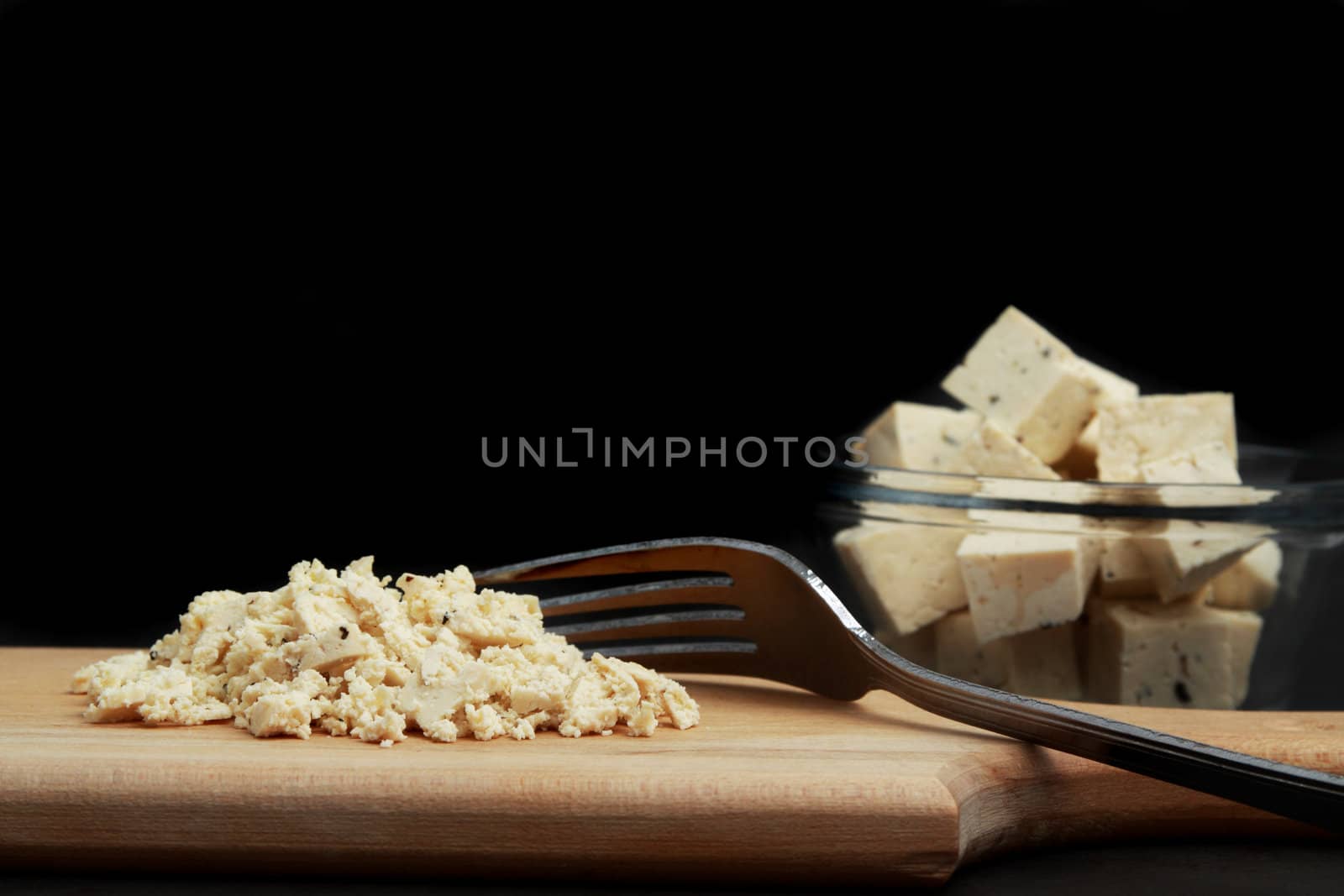 fresh fine herbs tofu in a bowl and wood plank with a fork