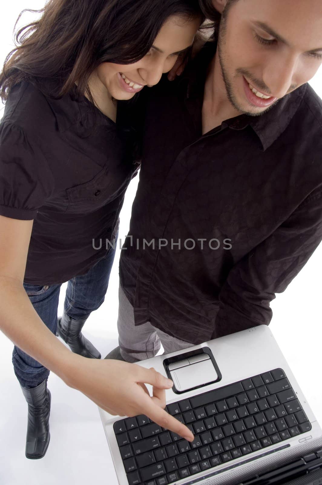 standing young couple looking into laptop with white background