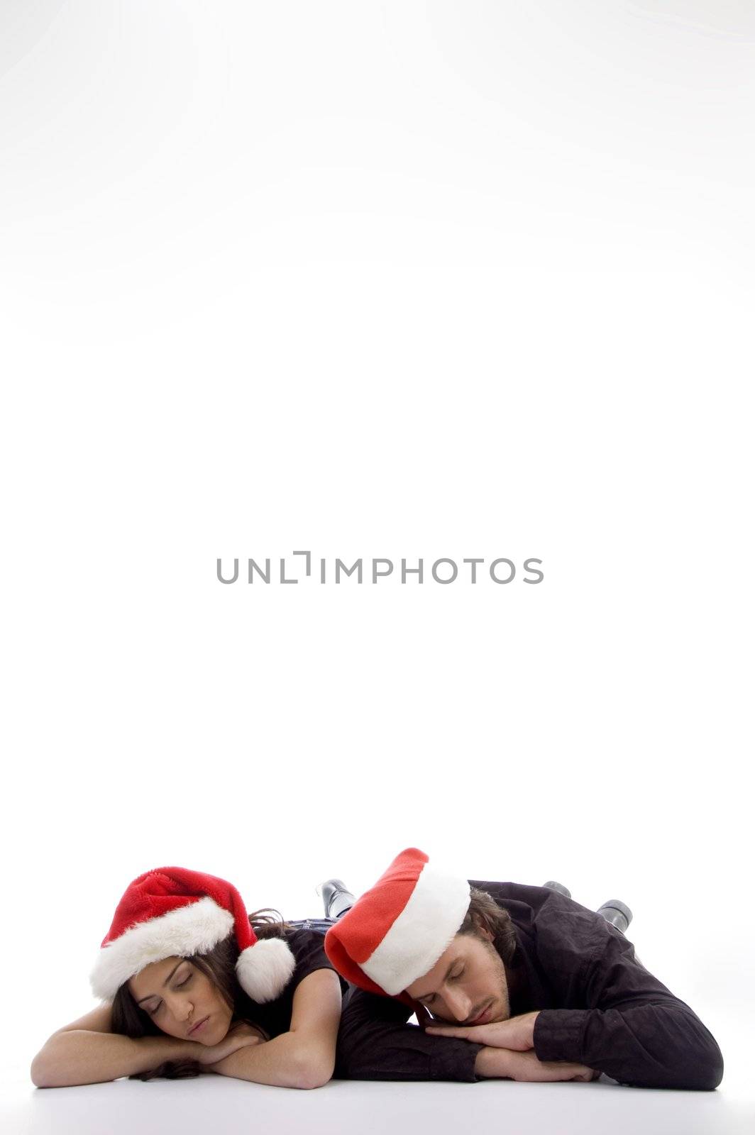 two friends lying on the floor with christmas hat by imagerymajestic