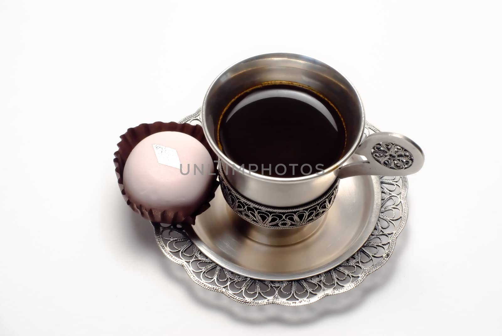 Silver cup of coffee with white cake is on the white background