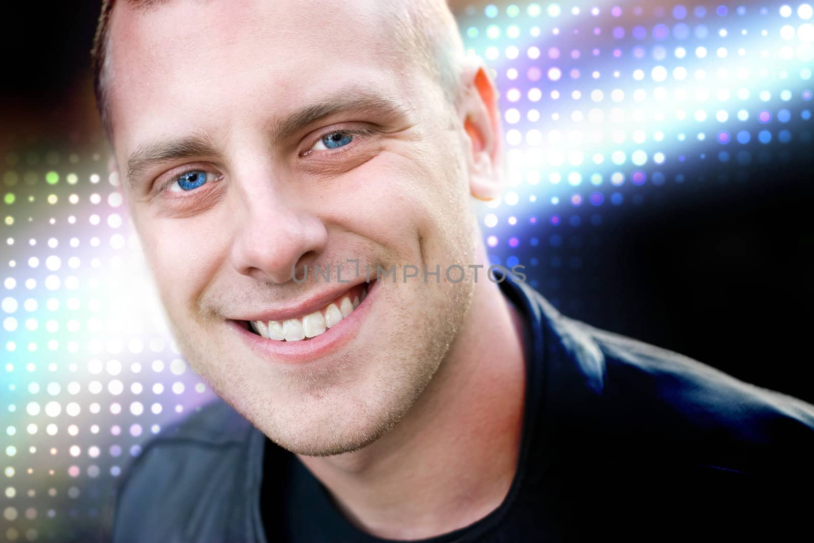 Closeup of the face of a happy young man with a big smile.  Abstract glowing halftone effects in the background.