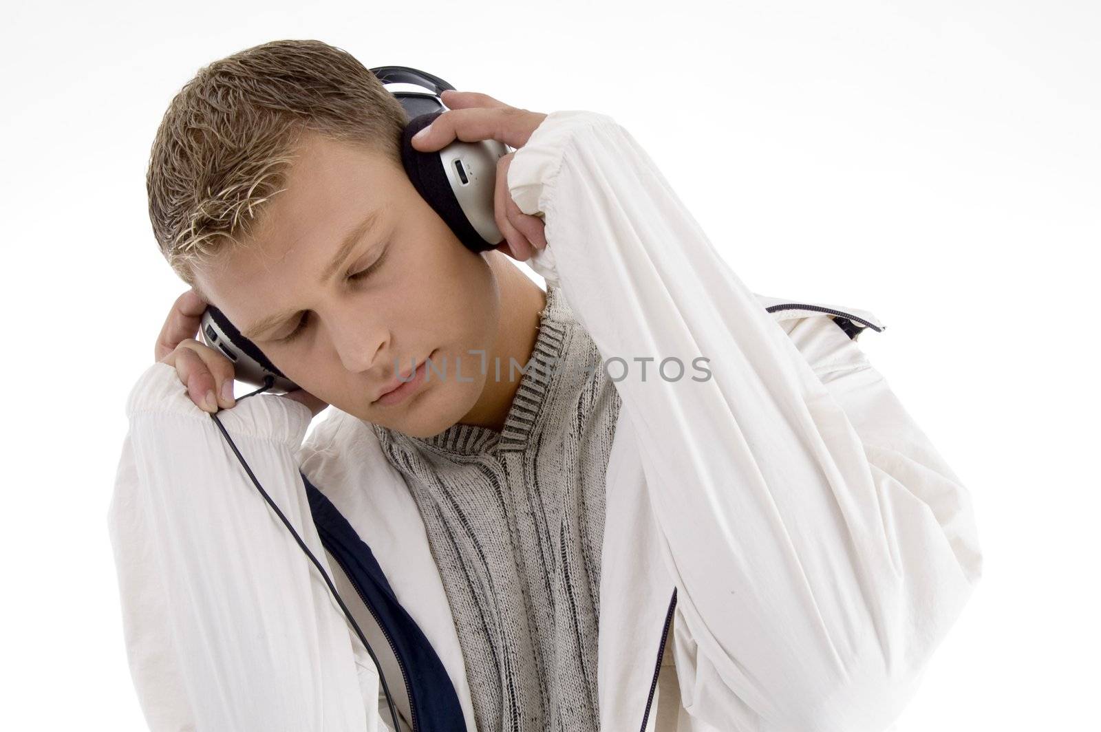 young handsome man enjoying music with headphones on an isolated white background