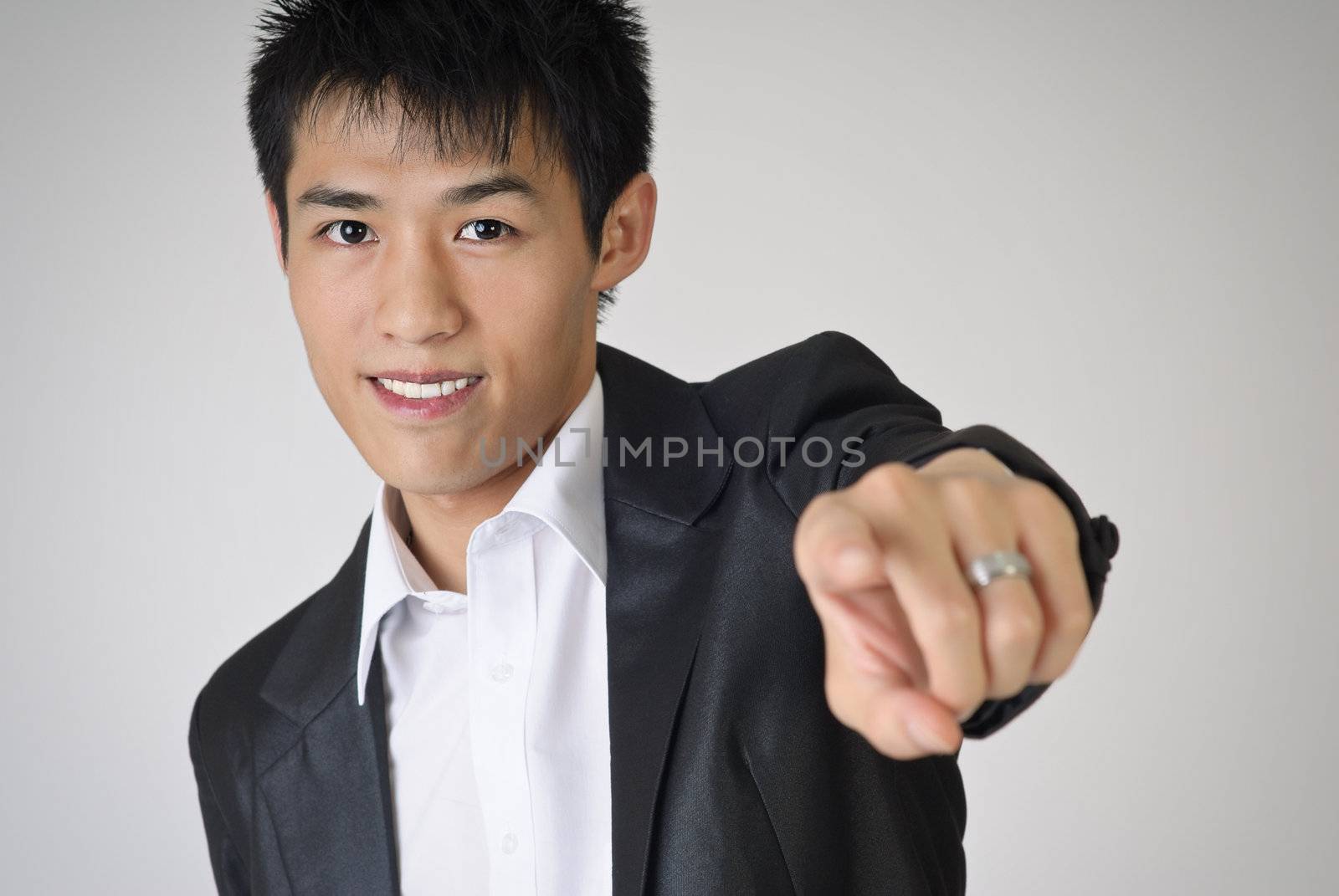 Young business man pointing out towards you with smiling face.