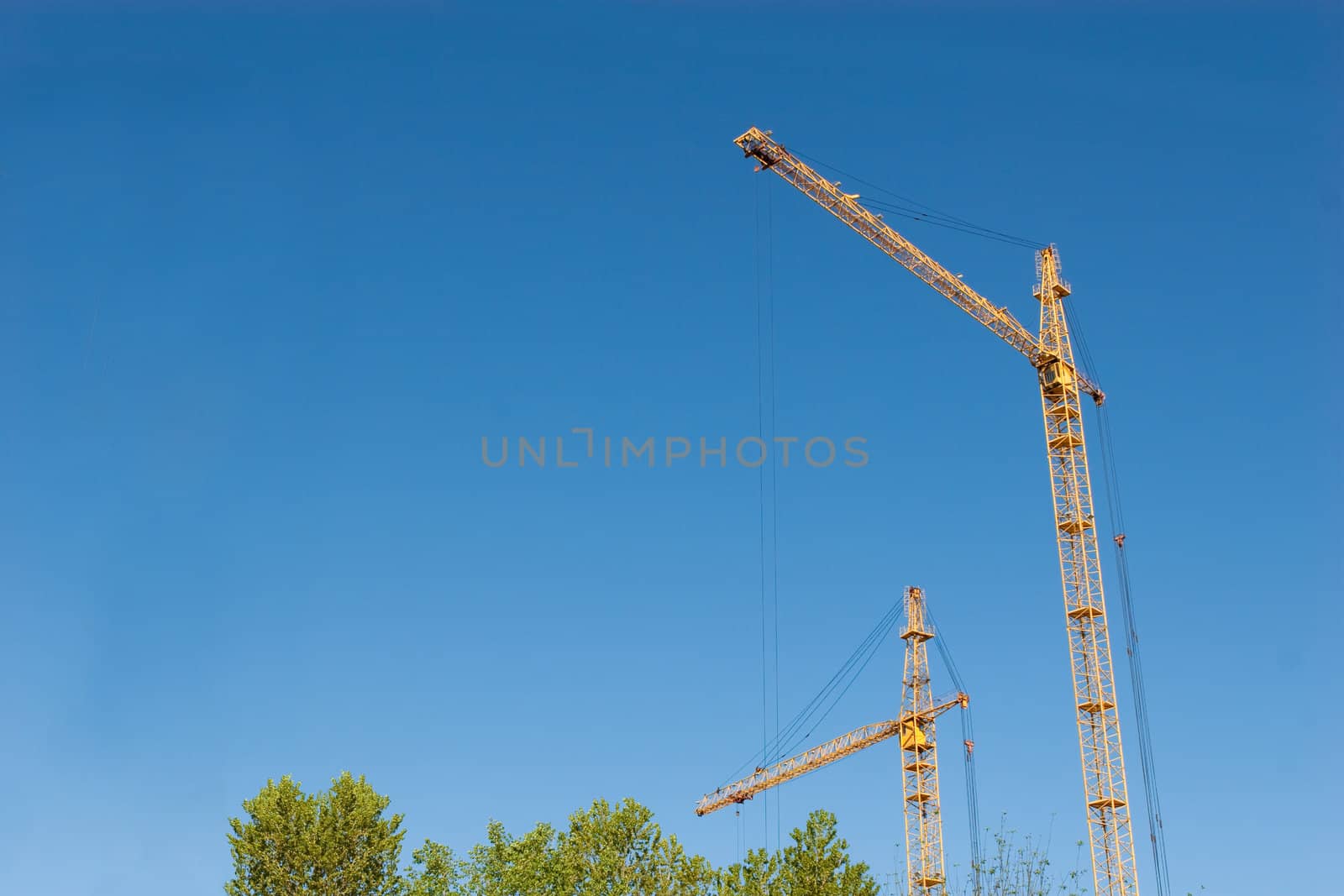 two hoisting cranes and the sky