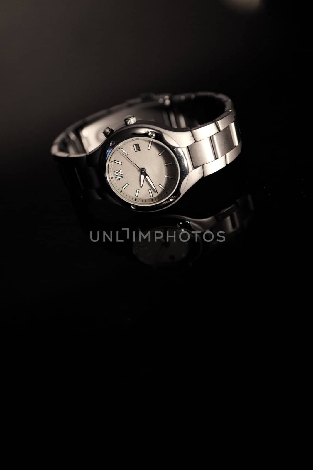 wristwatch on the glass on black background