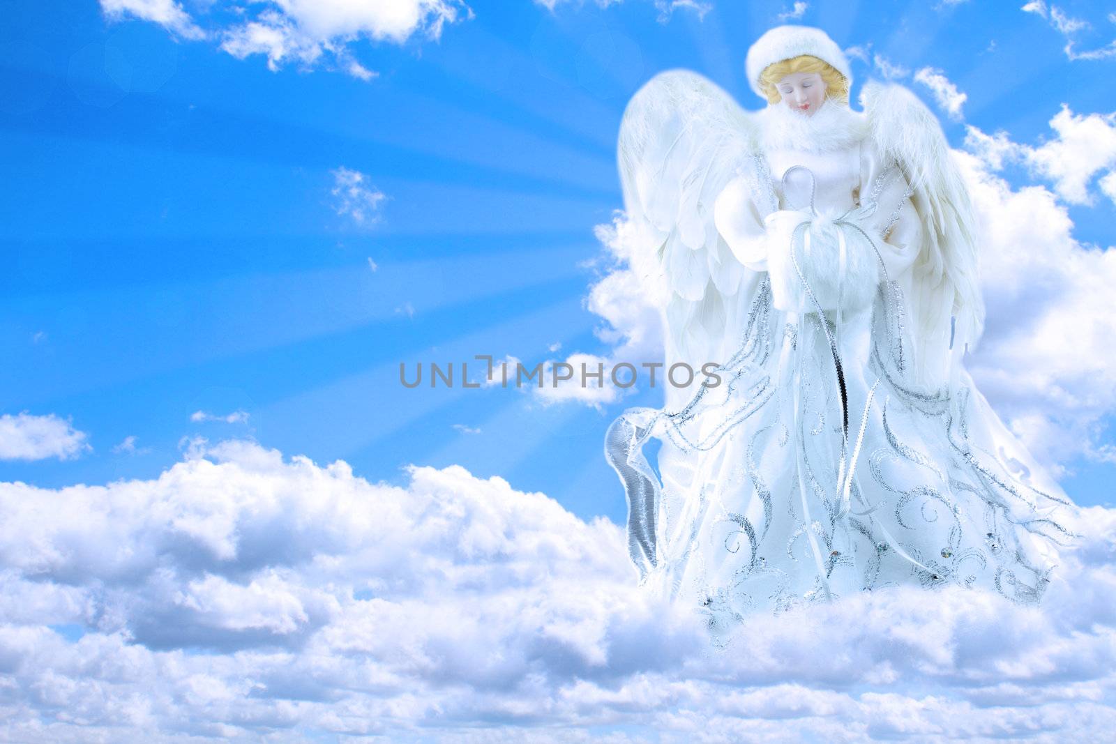 Beautiful generic angel praying in the sky with rays of light coming from behind her.