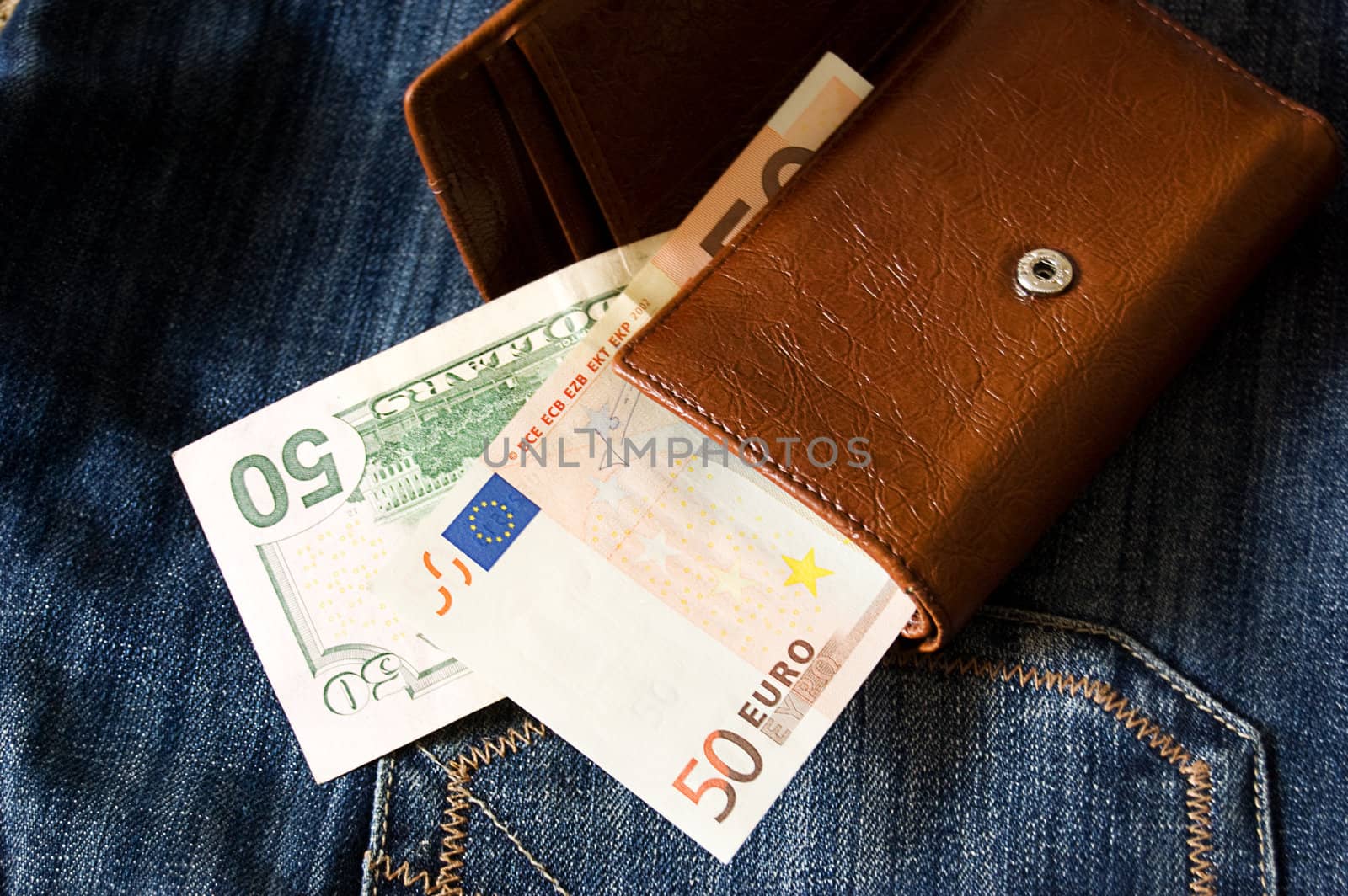 Fifty dollar and euro banknotes in wallet on jeans