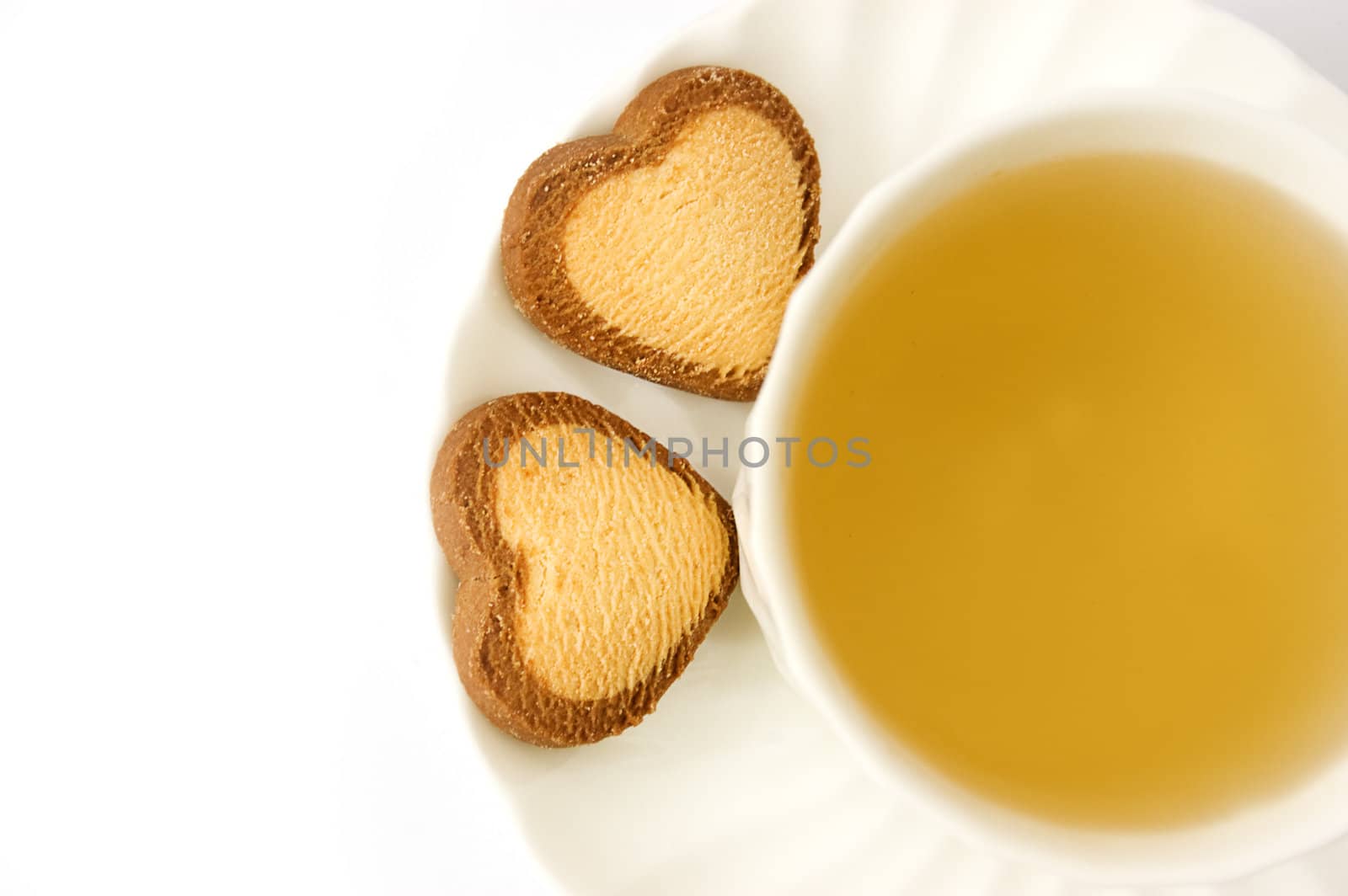 Cup of green tea and heart shaped biscuits