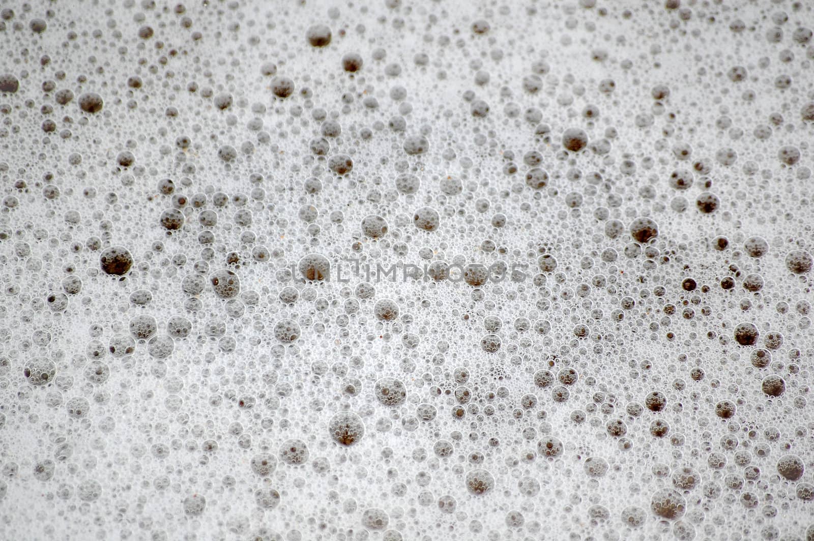 Texture of ocean bubbles on wet sand