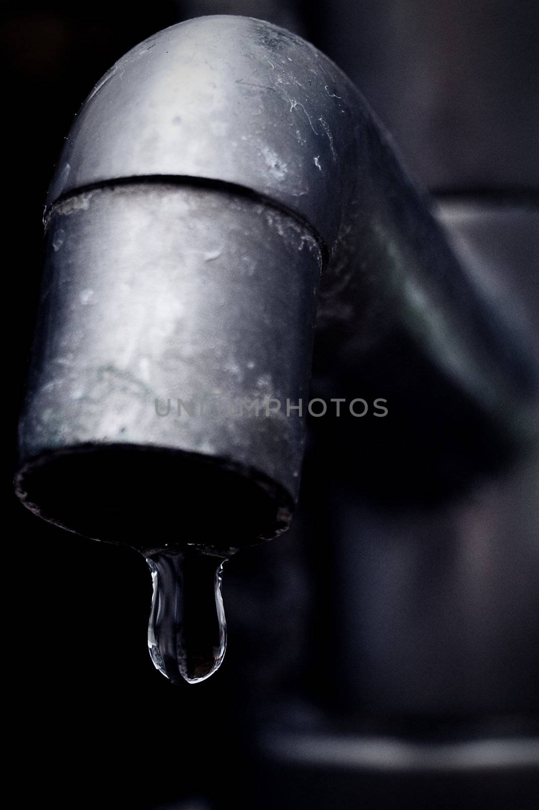 Old leaky faucet focus on water drop by nihues