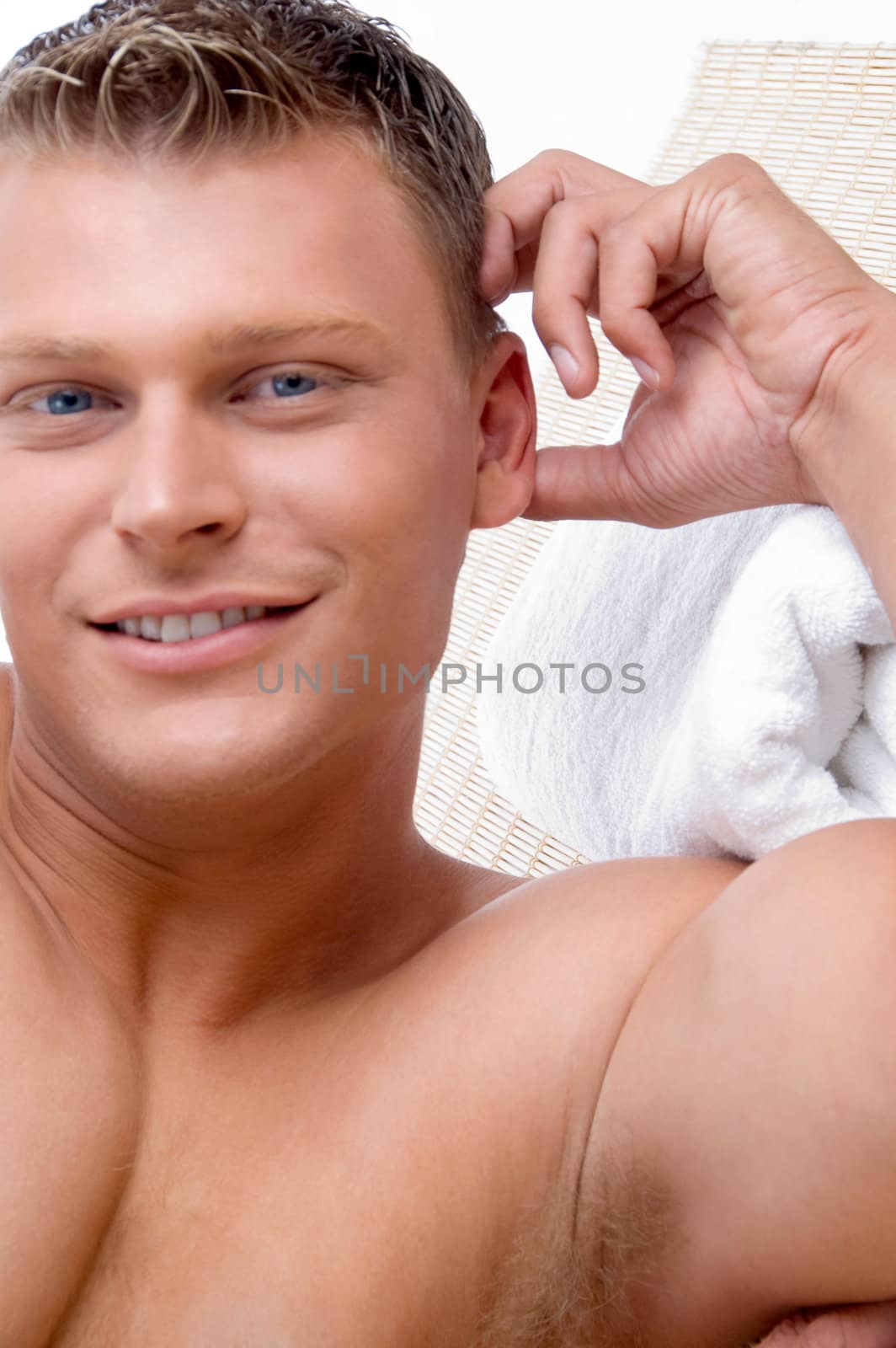 young male lying on mat ready to take spa treatment on an isolated white background