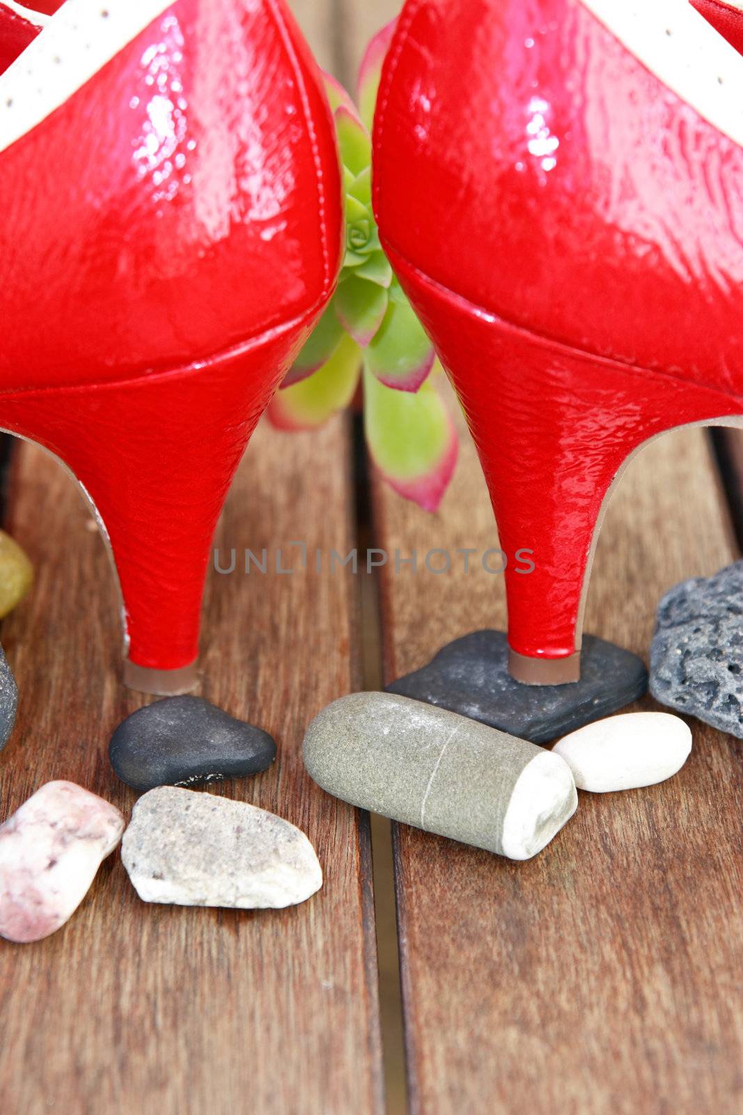 a pair of red high heels on top of pebbles