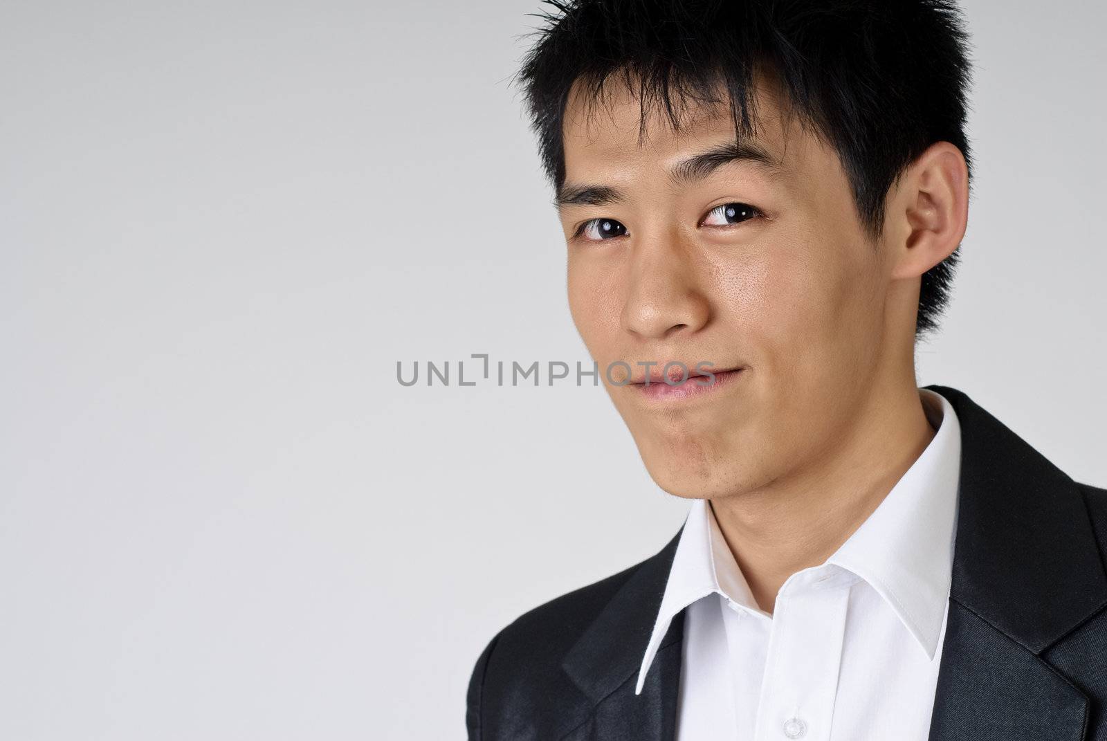 Young handsome business man portrait with smiling expression, closeup.