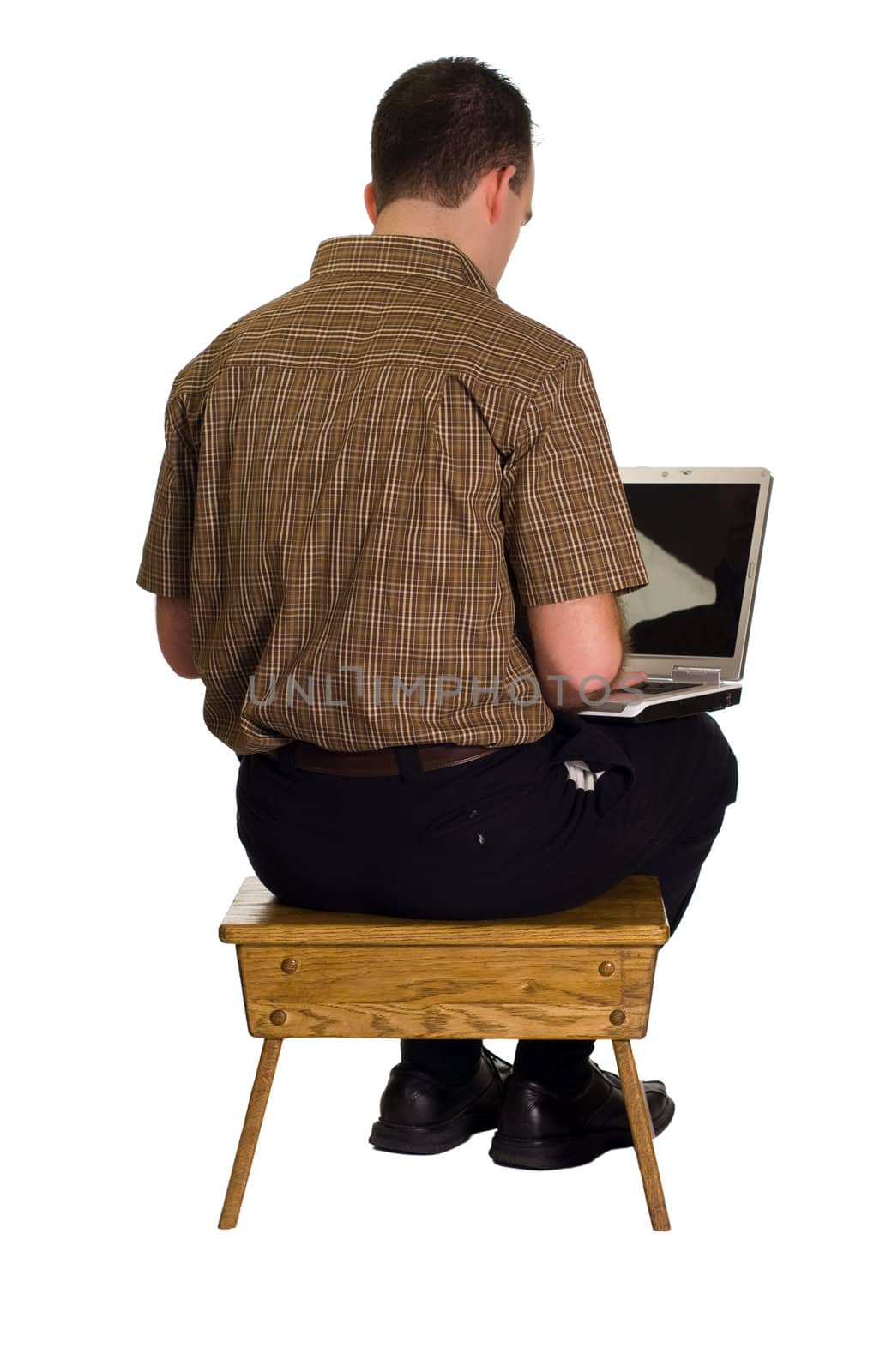 A man sitting on a wooden stool and working on his laptop computer, isolated against a white background