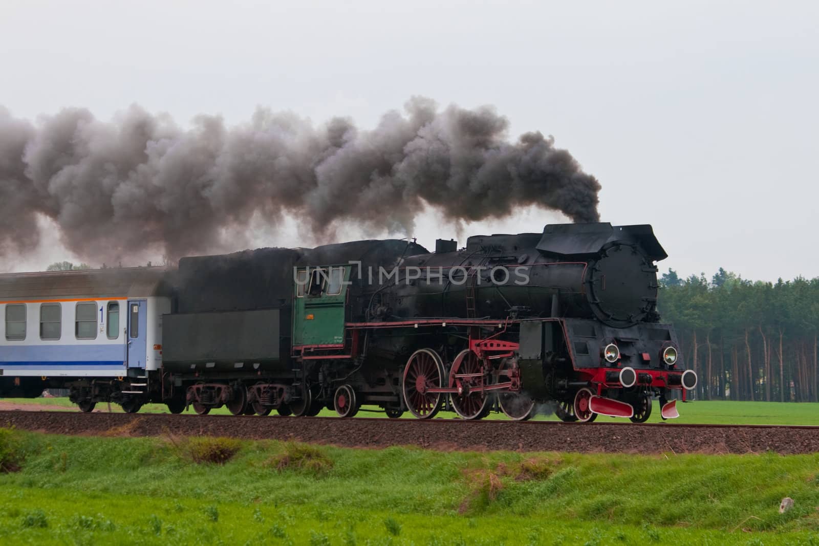 Old retro steam train passing through polish countryside
