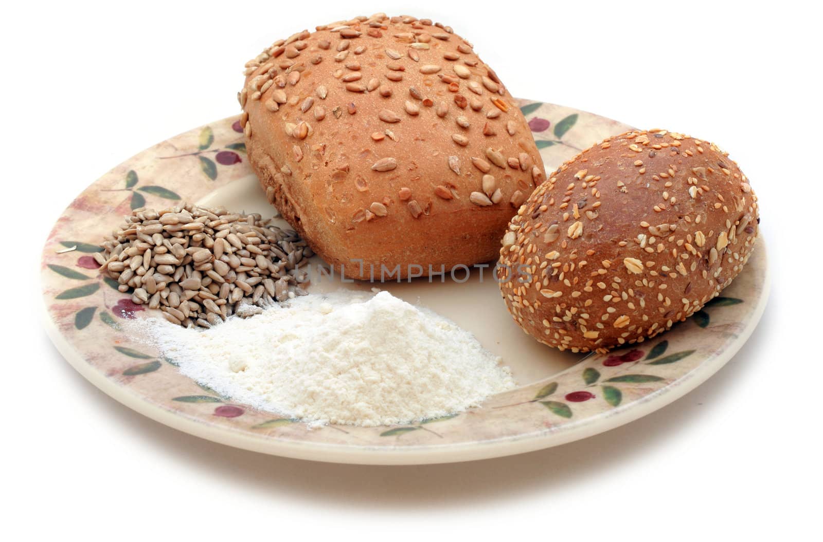 Whole-meal rolls, sunflower grain and flour on the plate