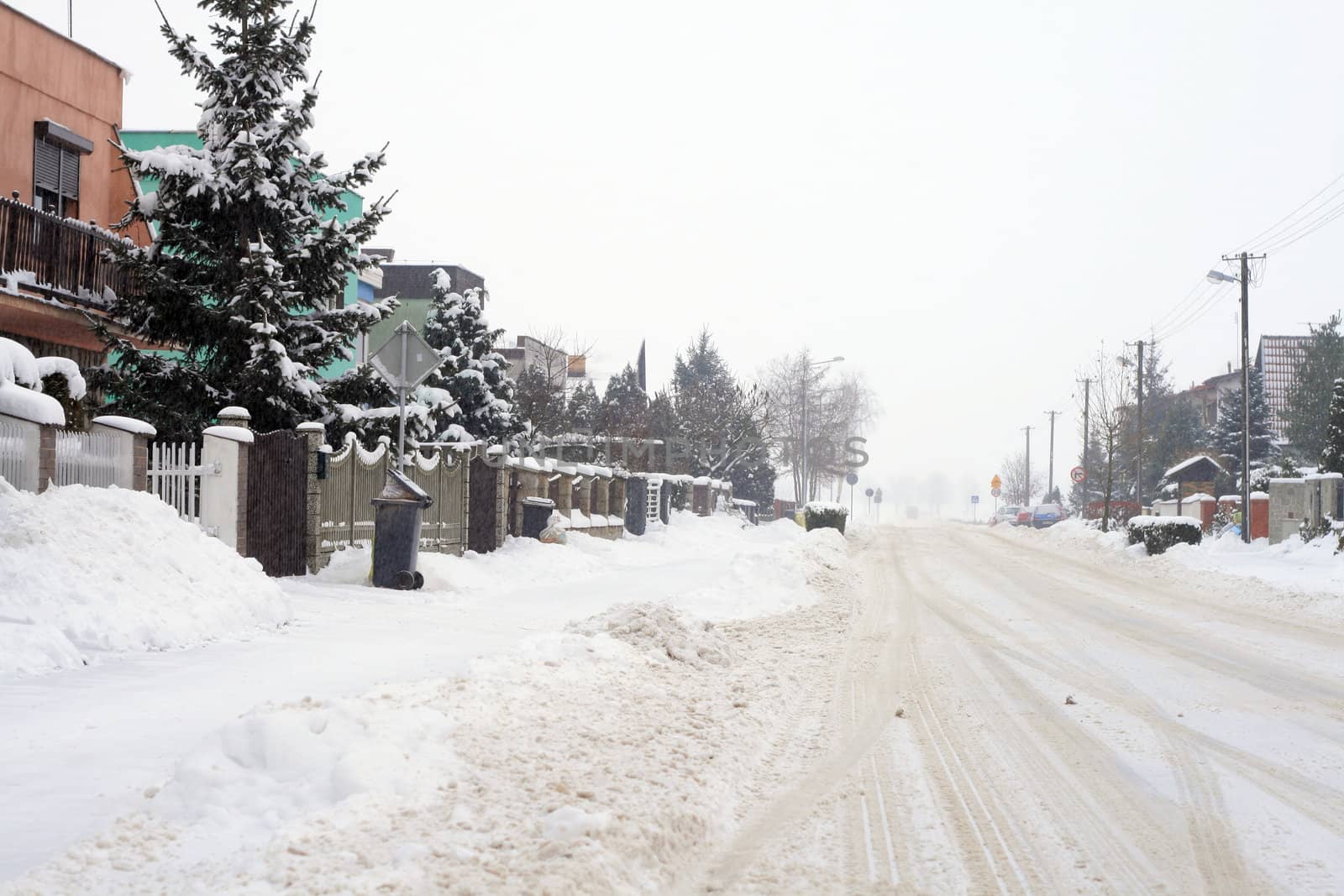 Snowy road leading through the village during wintertime