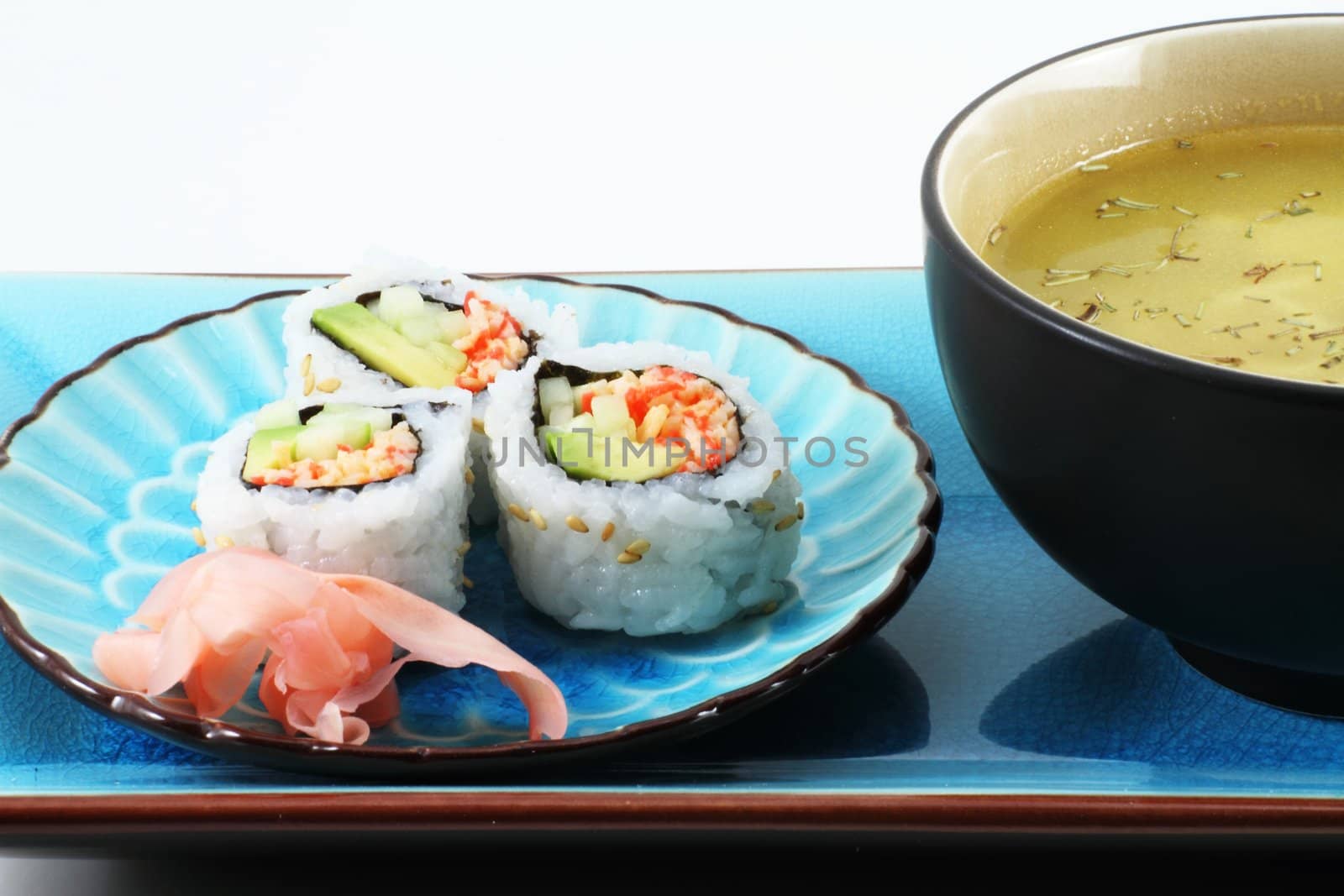 Fresh Sushi with ginger root and soup on an oriental table setting.