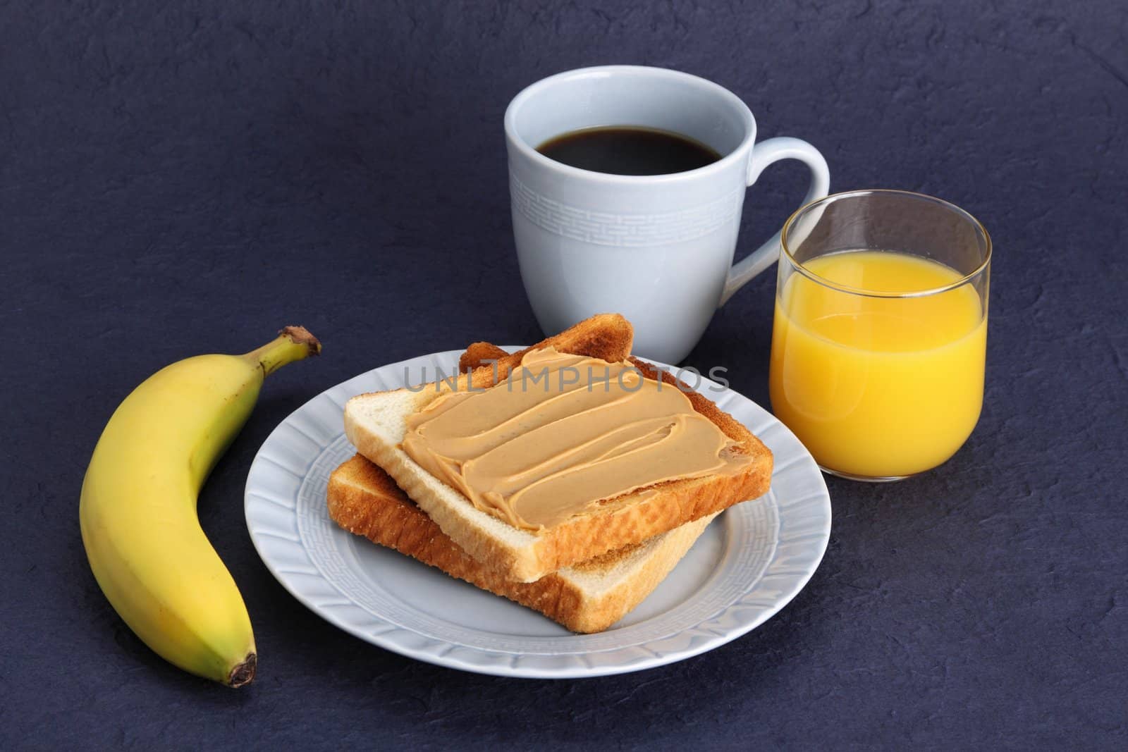 peanut butter toast in blue plate with orange juice, coffe and banana