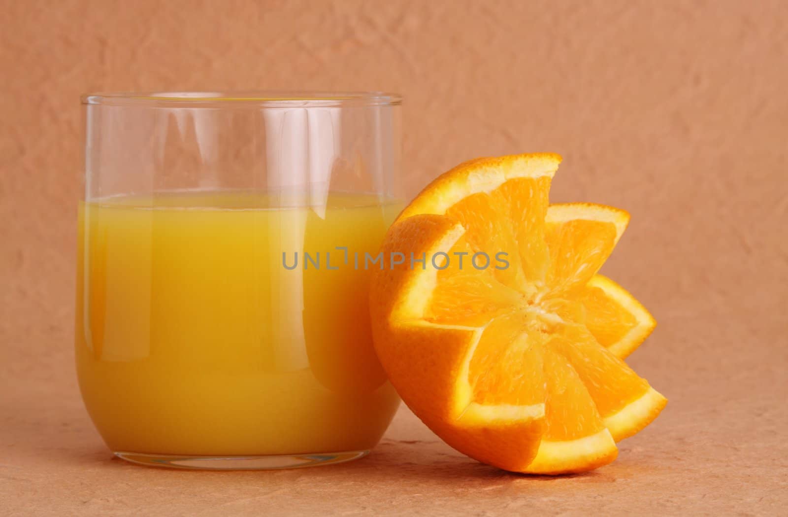 glass of orange juice with half fruit beside