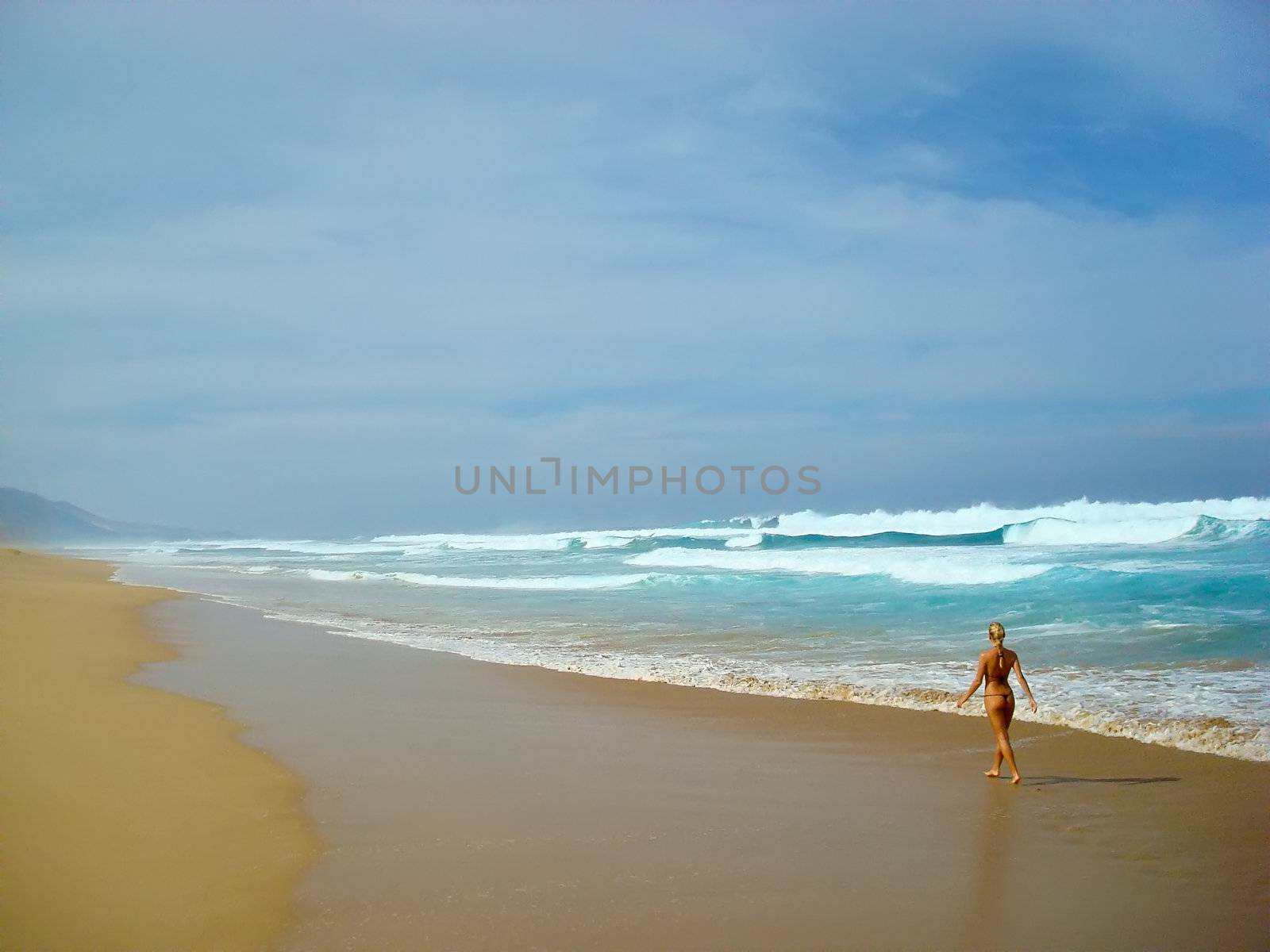 Young lady walking alone along the beach