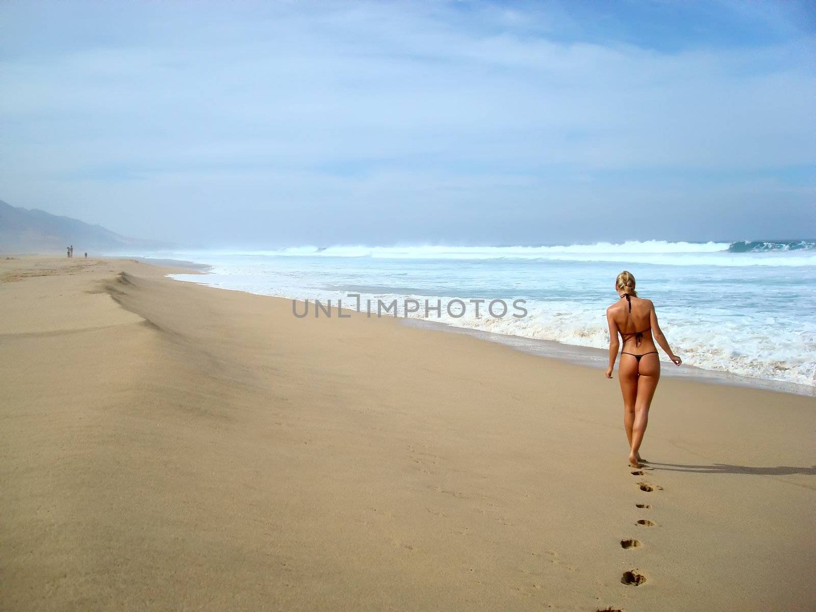 Young lady walking alone along the beach