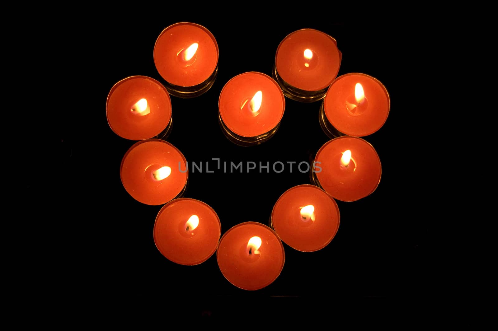 candles heart shaped on black background