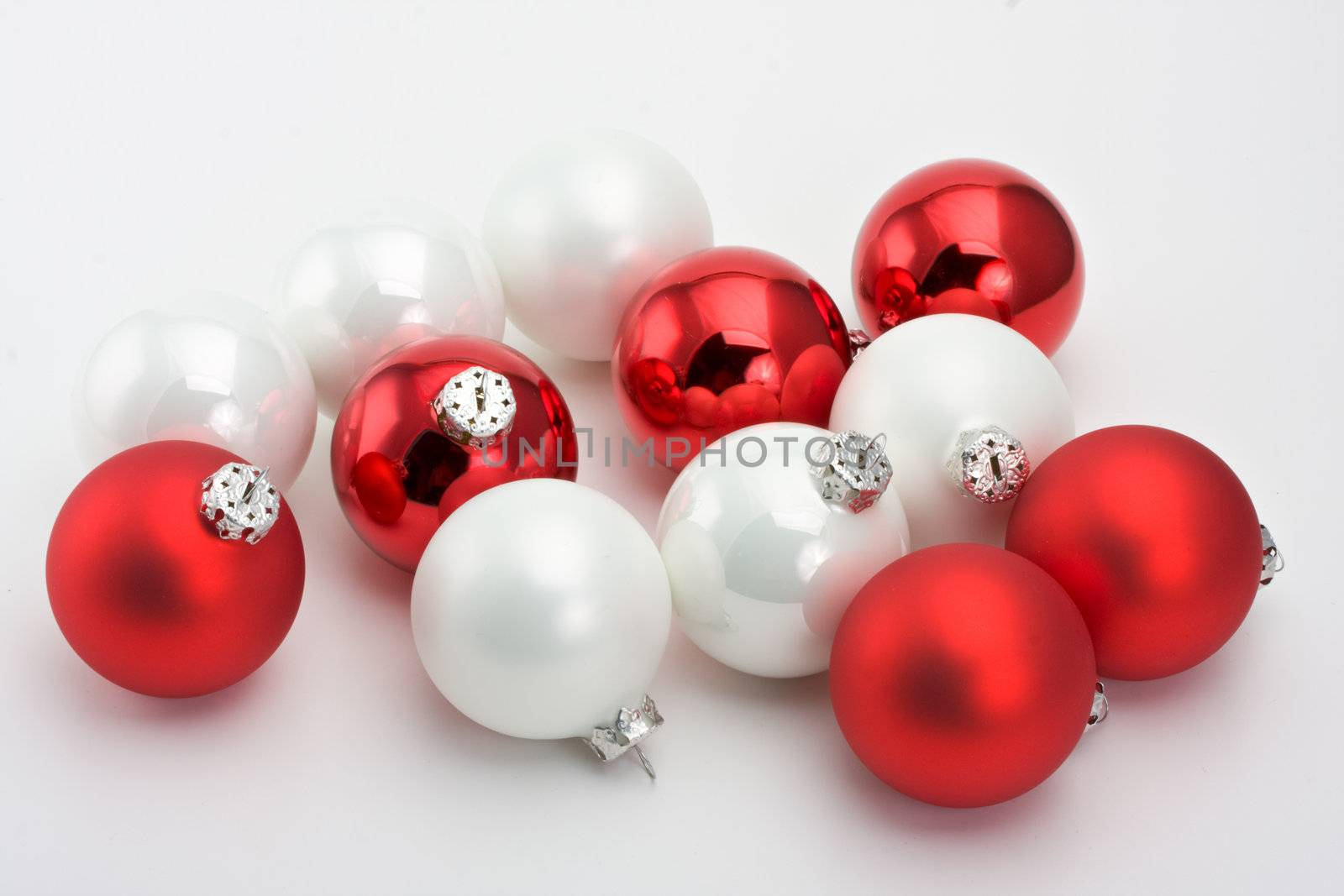 white and red christmas baubles on a light grey background